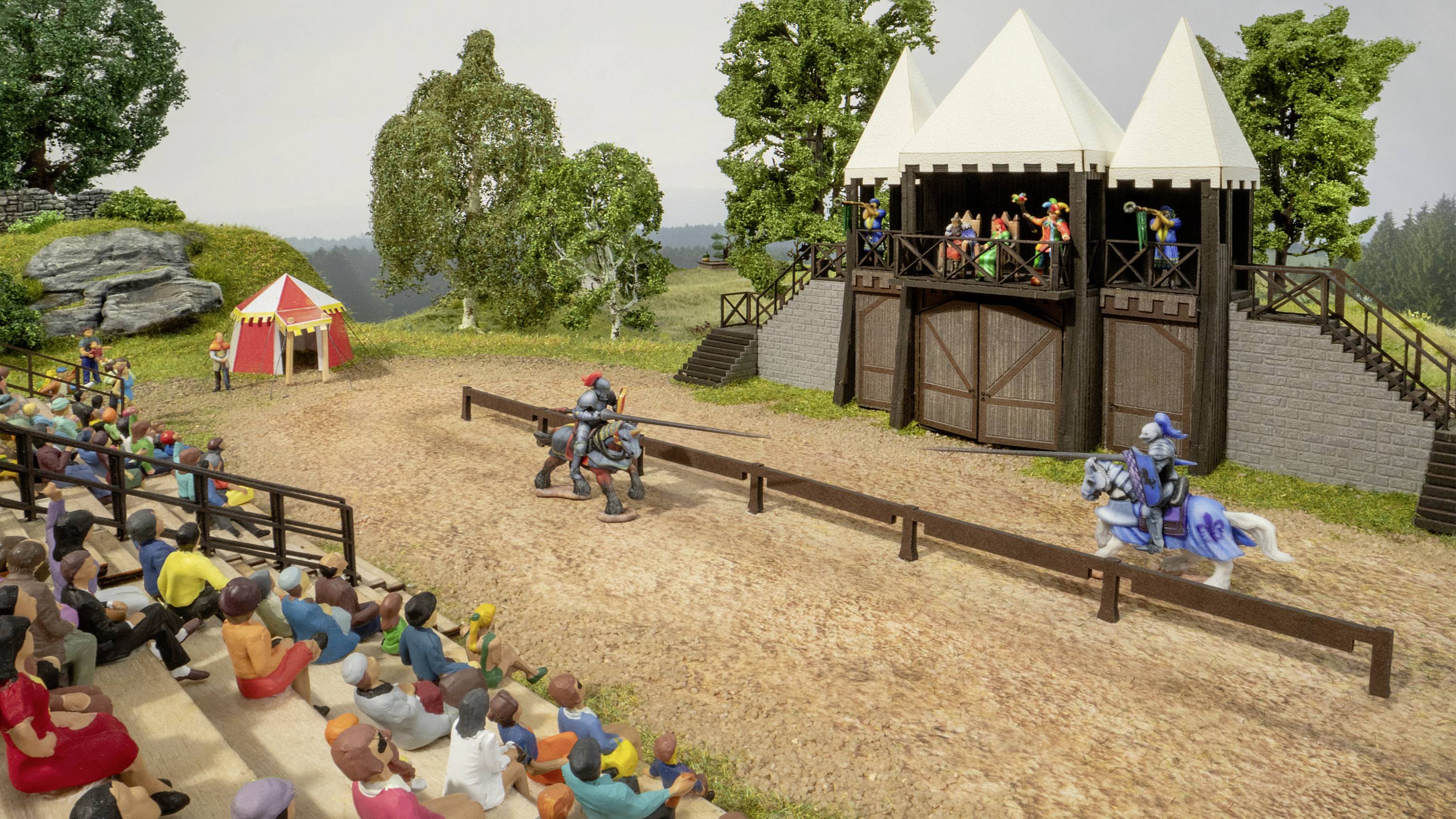 Zwei Ritter auf Pferden kämpfen im Tjost, während Zuschauer auf der Tribüne und im Zelt zusehen. Ein grüner Wald bildet den Hintergrund.