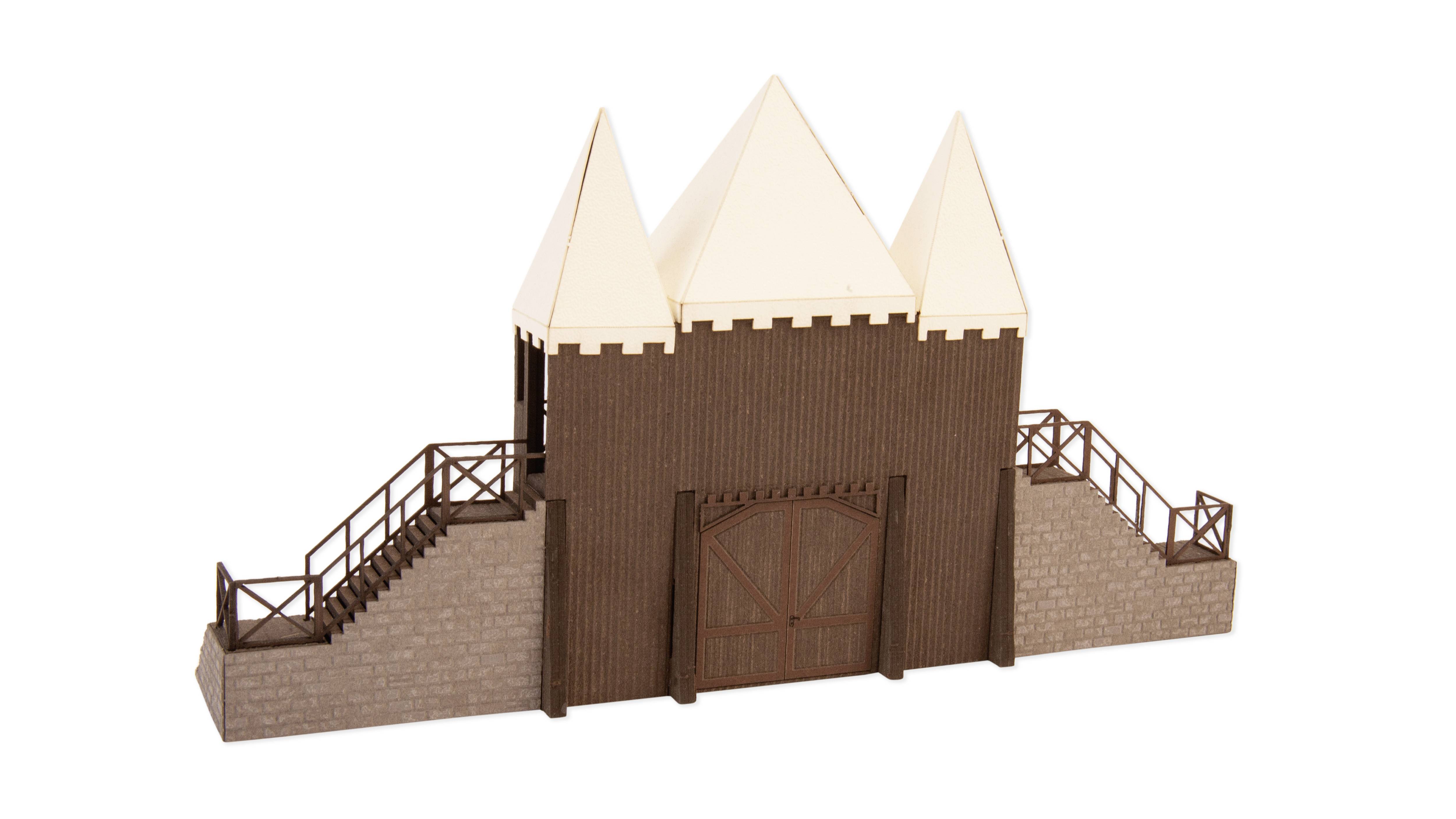 Ein Modell einer mittelalterlichen Burg mit drei weißen, spitzen Türmen, zwei seitlichen Steintreppen und einem Holztor in der Mitte.