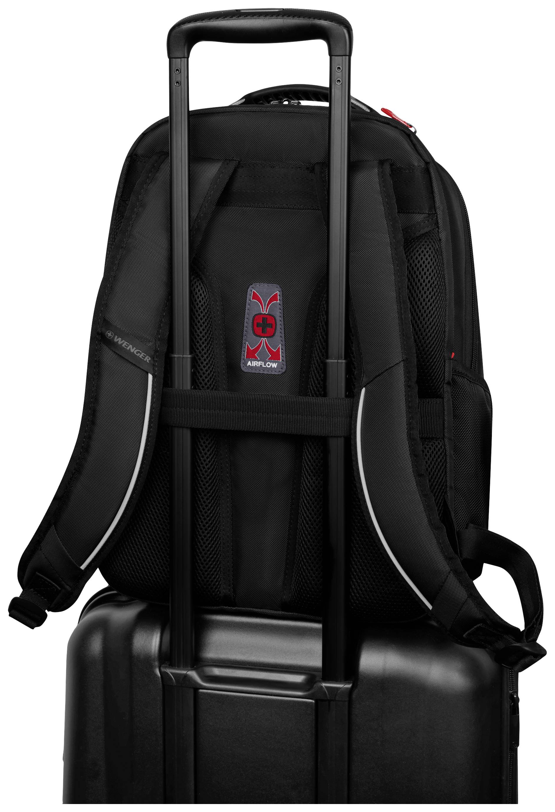 Schwarzer Rucksack auf einem Koffer befestigt, mit aufrechtem Griff.