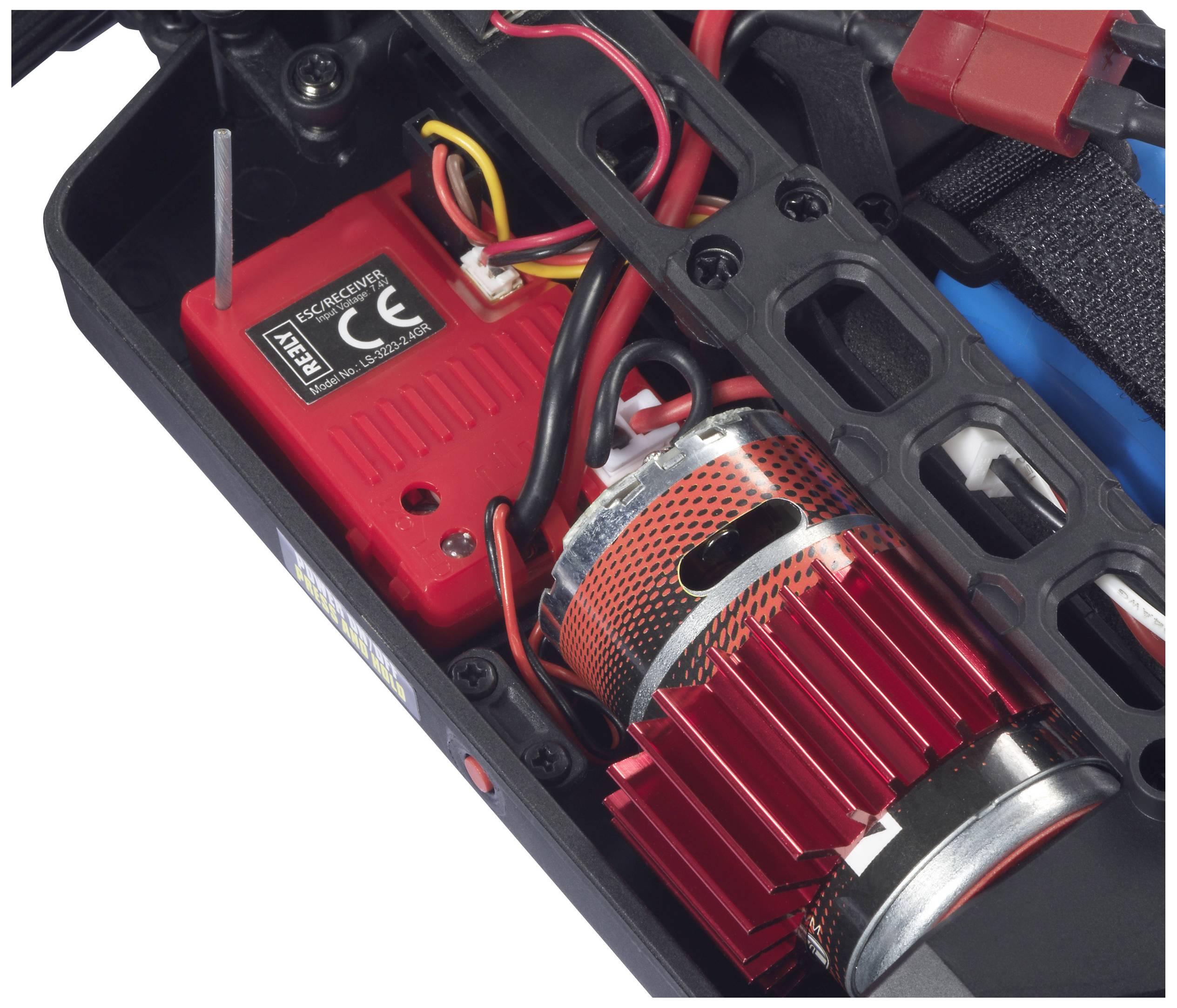 Ein roter Elektromotor mit Kühlrippen in einem ferngesteuerten Auto, umgeben von Kabeln und einem Kontrollgerät, sichtbar im Inneren.