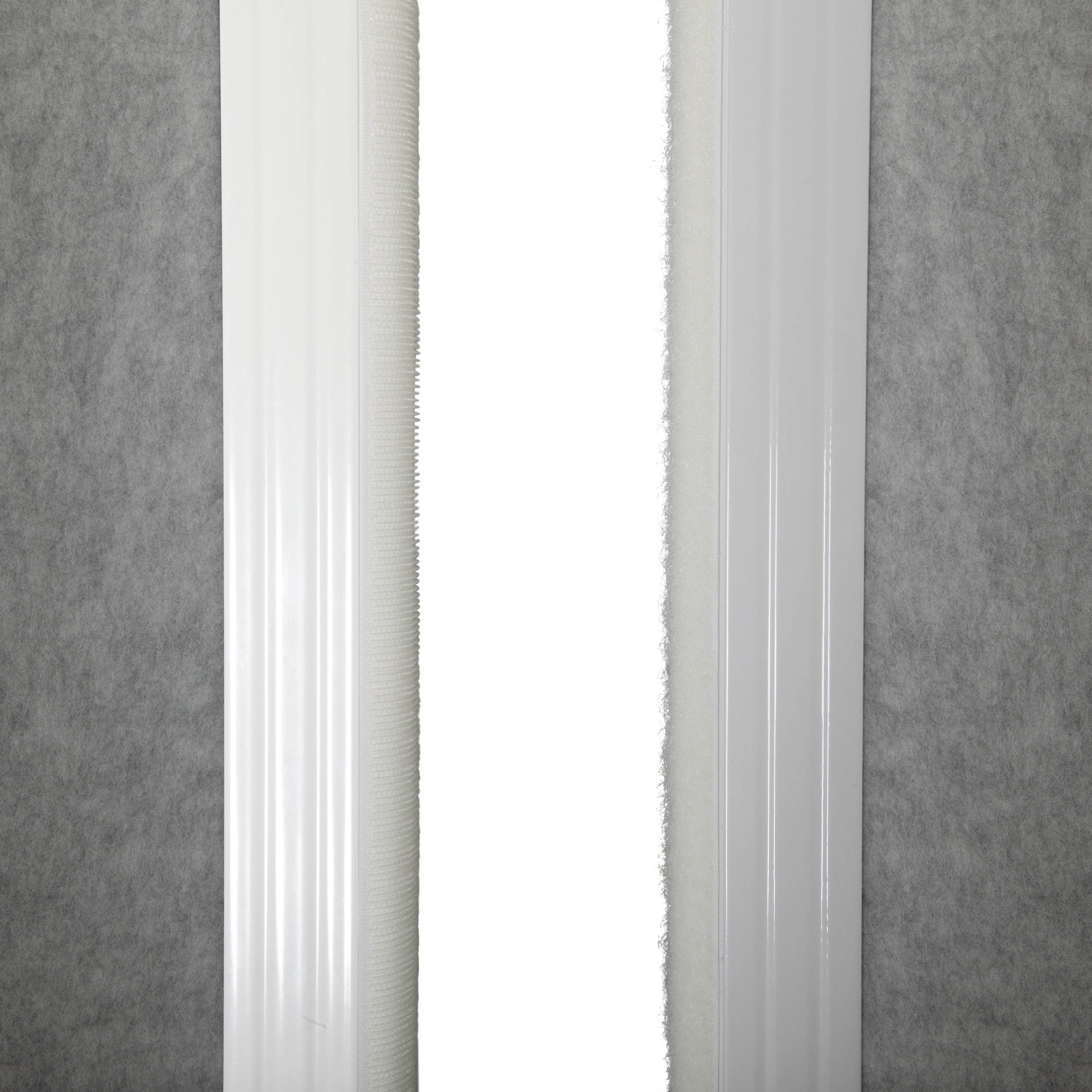 Ein weißer, vertikaler Streifen in der Mitte einer grauen Stoffoberfläche; einfache, klare Architekturstruktur.