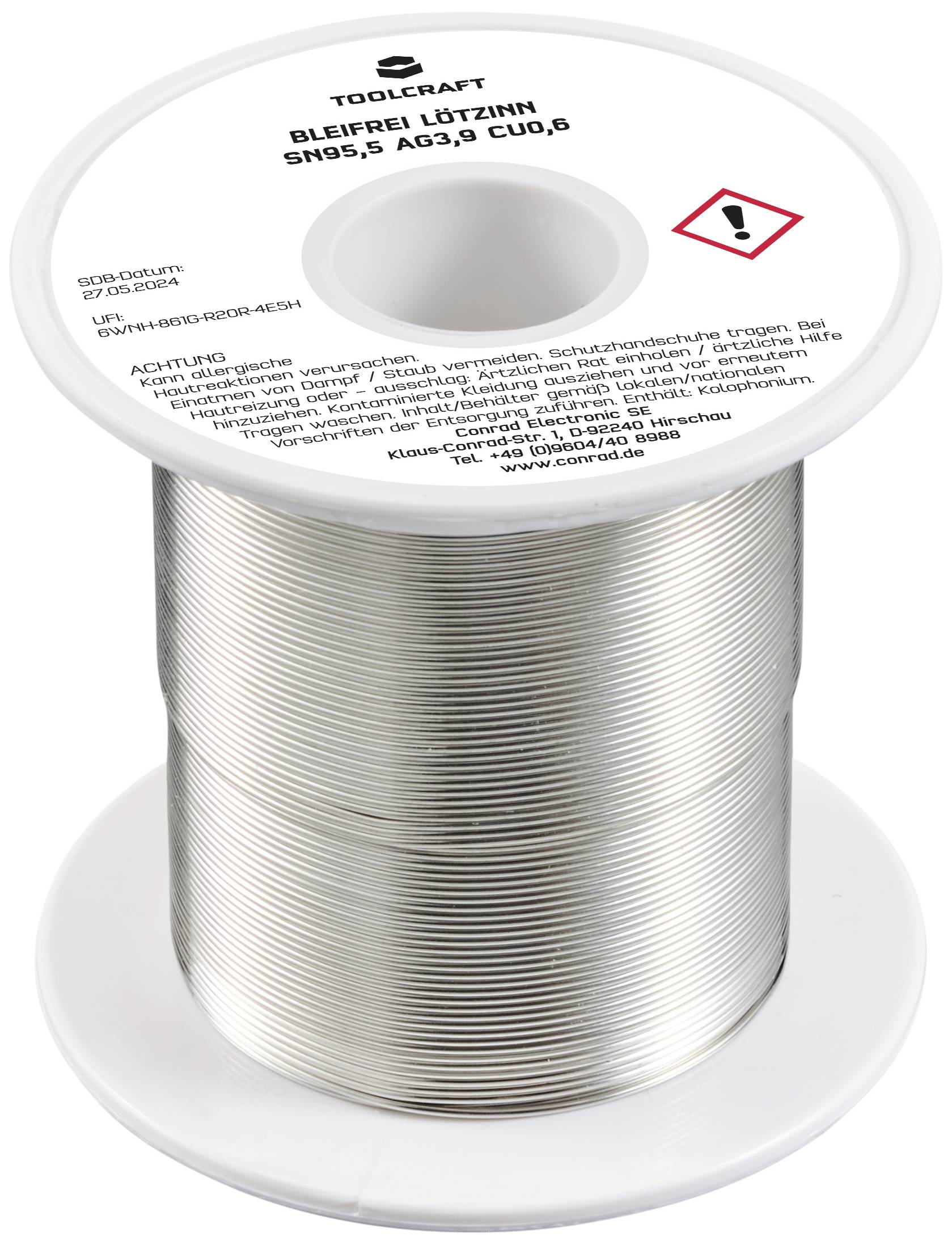 Lötzinnrolle mit Etikett: 'Bleifrei, Sn95,5, Ag3,8, Cu0,8'. Gefahrenhinweisetikett in roter Raute. Spule mit silbrig glänzendem Draht.
