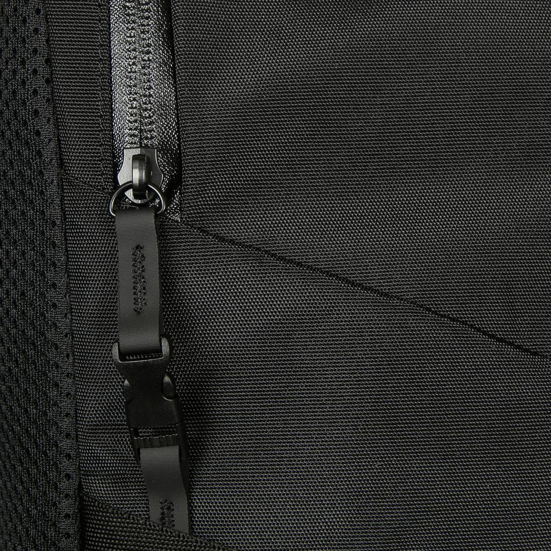 Nahaufnahme eines schwarzen Reißverschlusses an einer Tasche, zeigt Detail der Textur und Nähte des Stoffs.