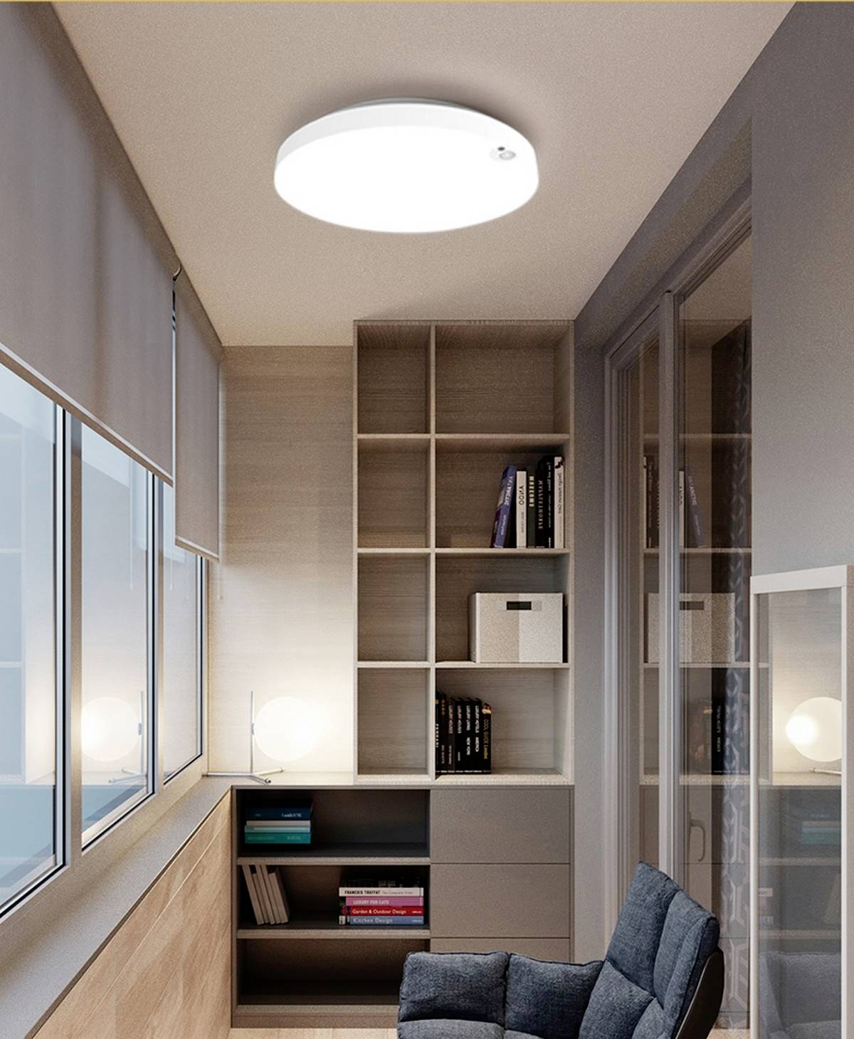 Ein kleiner Arbeitsbereich mit einem Wandregal voller Bücher, einem bequemen Stuhl und einer hellen Deckenlampe.