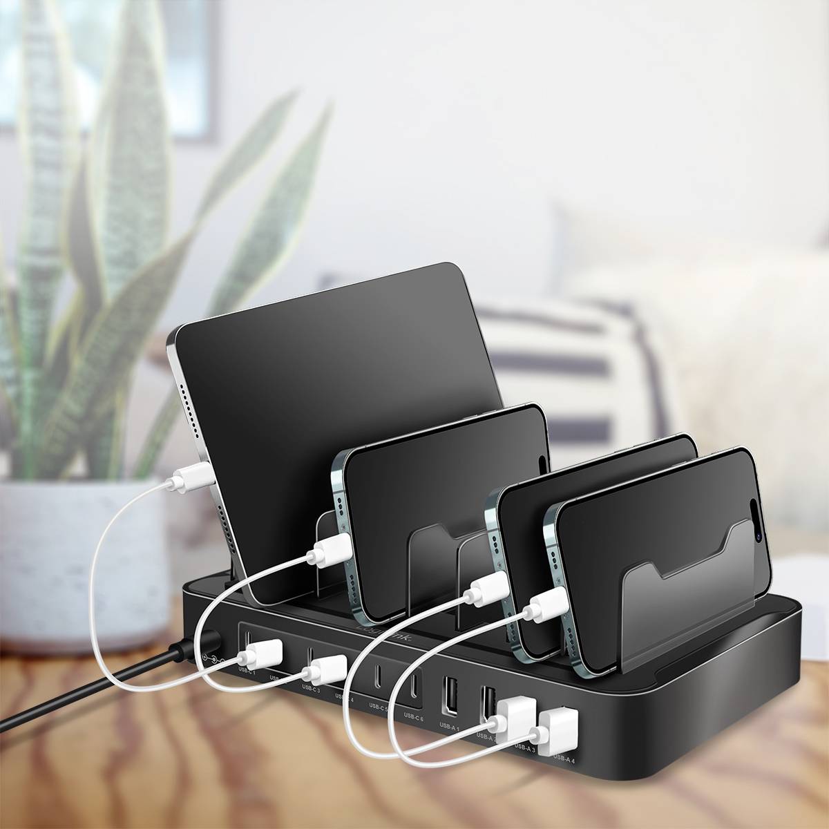 Mehrere mobile Geräte, darunter Smartphones und ein Tablet, werden gleichzeitig auf einem kompakten Ladeständer mit mehreren USB-Anschlüssen aufgeladen.