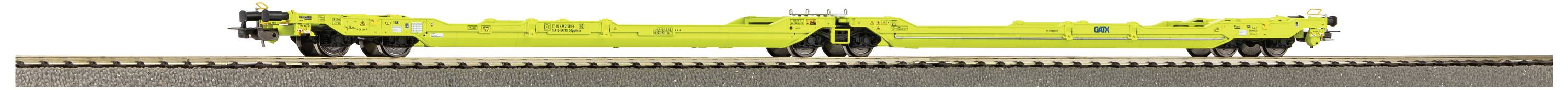 Ein leuchtend gelber Eisenbahn-Tragwagen mit flachem Aufbau steht auf Gleisen. Keine Ladung zu sehen.