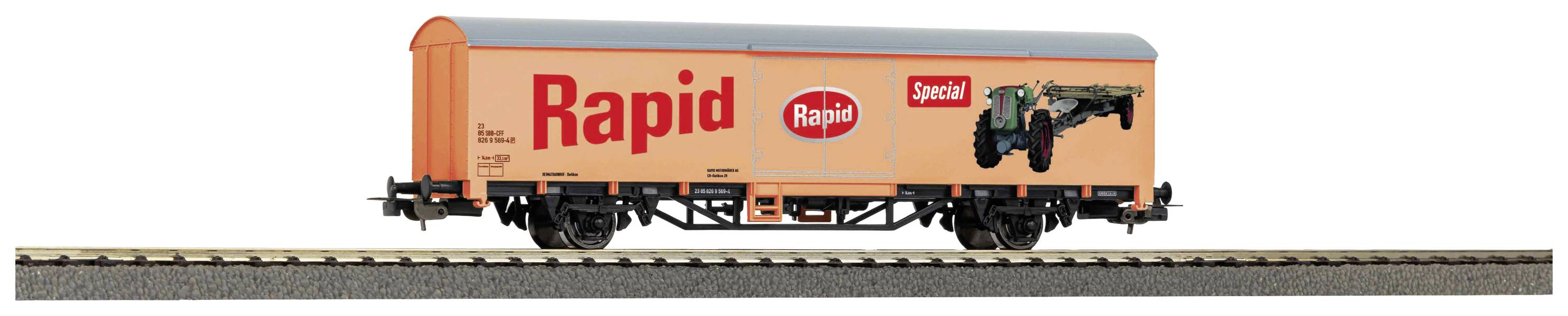 Ein orangefarbener Güterwagen mit der Aufschrift 'Rapid'. Der Wagen fährt auf einem Gleis.
