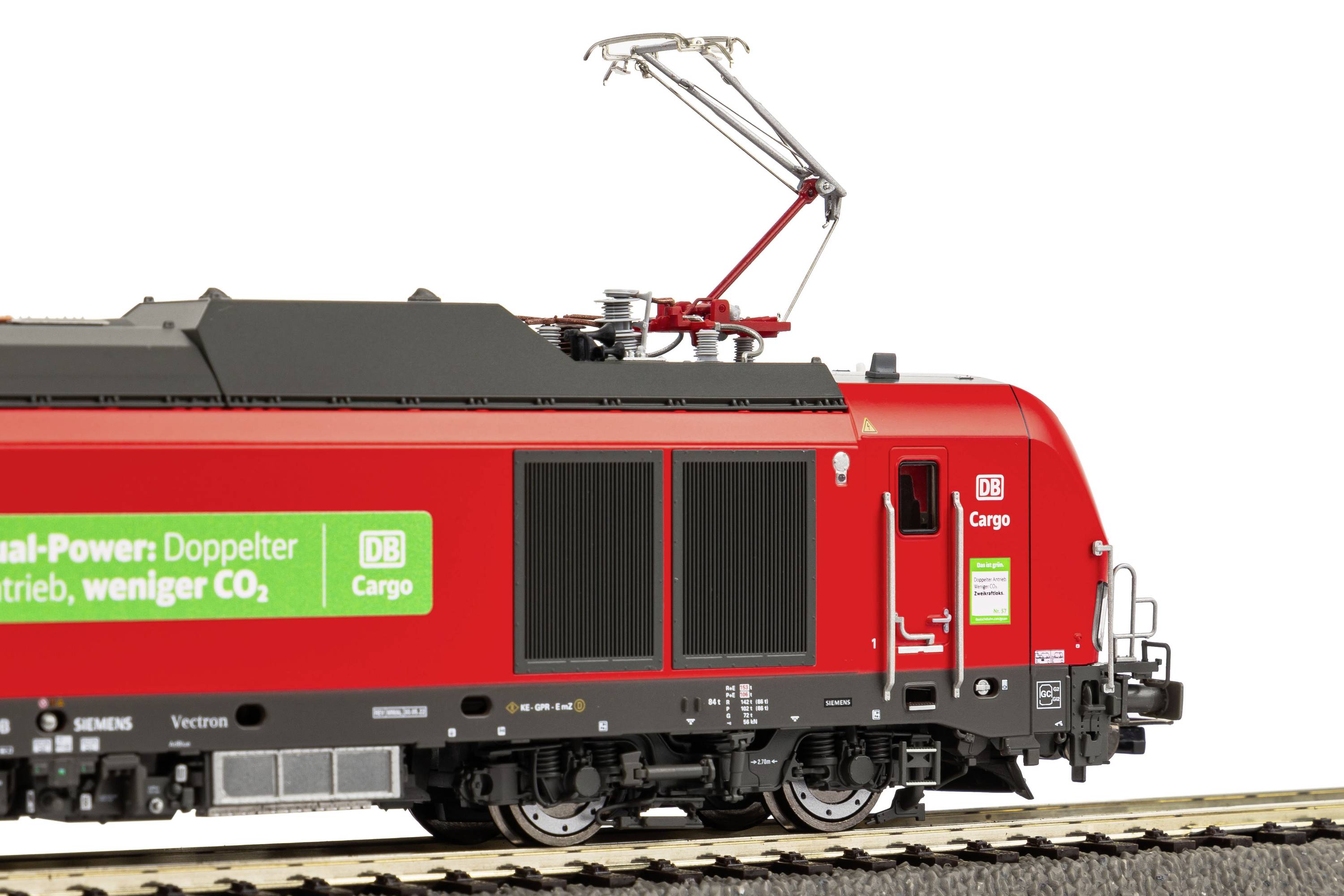 Eine rote Güterzuglokomotive mit dem Logo der Deutschen Bahn und einer grünen Werbung, die Nachhaltigkeit fördert.