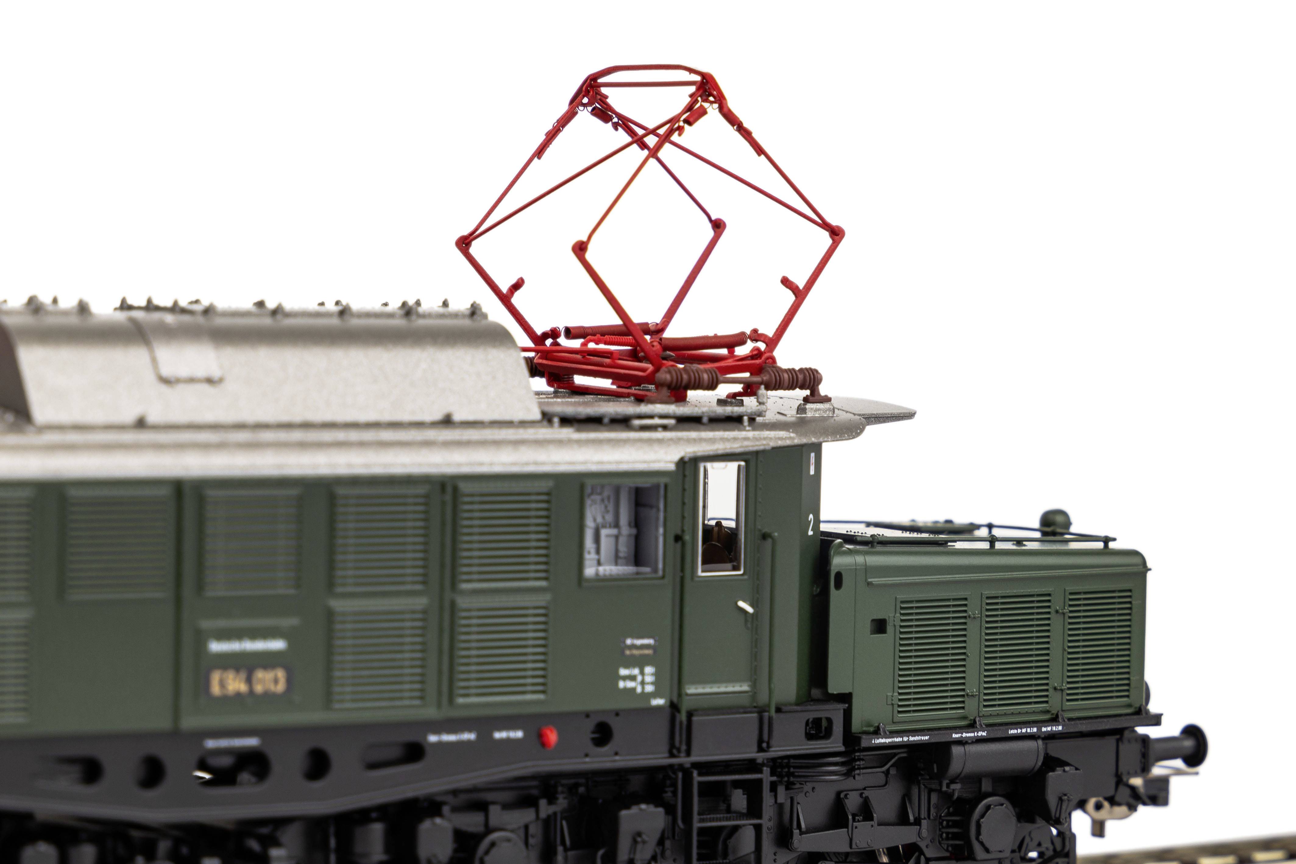 Ein detailliertes Modell einer historischen grünen Elektrolokomotive mit Stromabnehmer auf dem Dach, fokussiert auf die obere Ansicht.