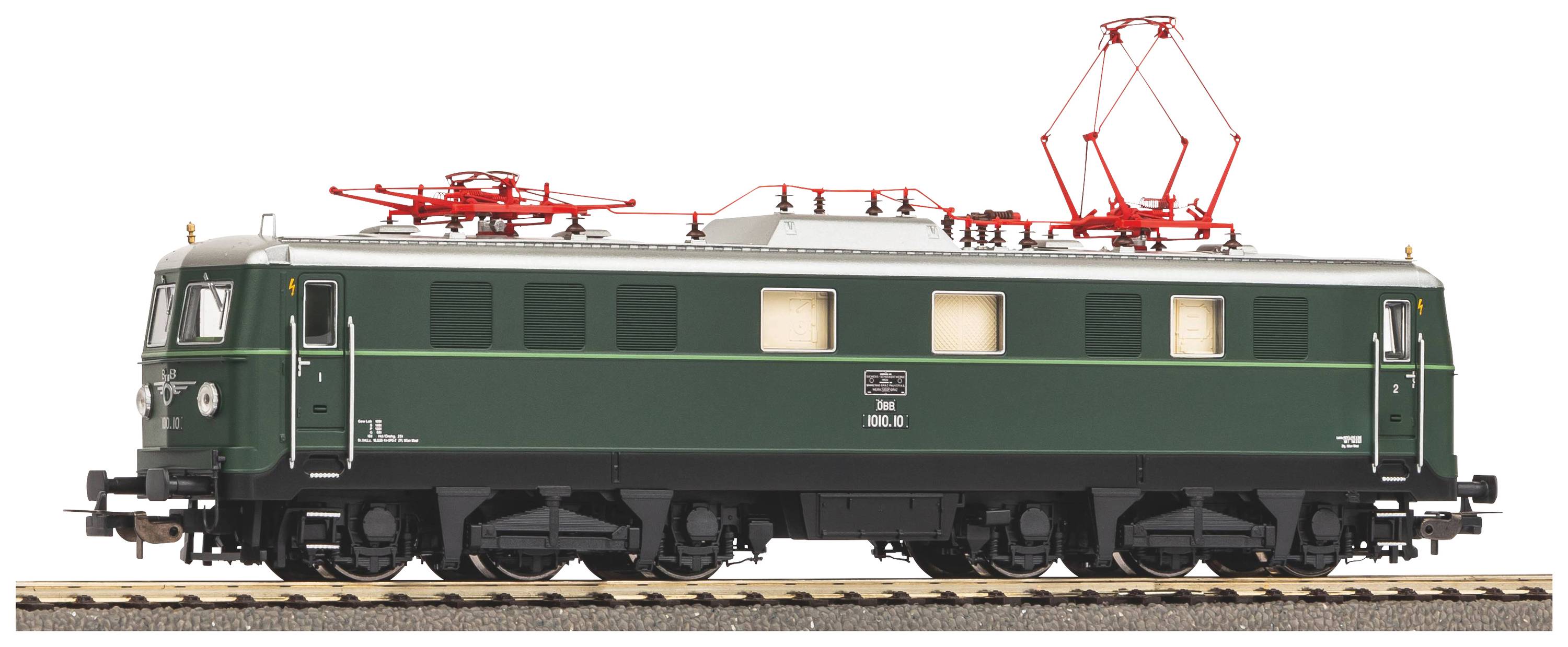 Eine grüne Elektrolokomotive mit rotem Stromabnehmer steht auf einem Gleisabschnitt. Sie hat weiße Fenster und zeigt ein klassisches Design.