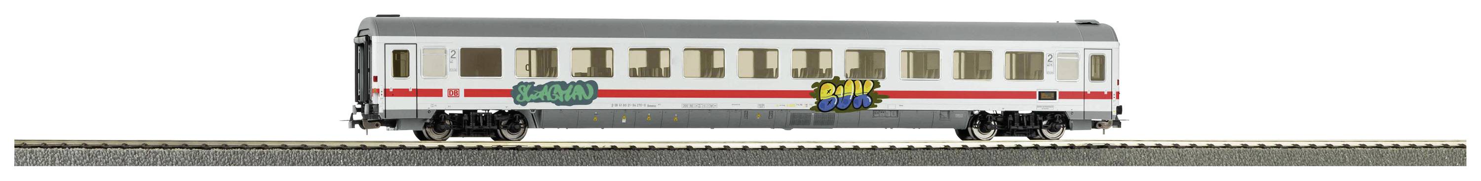 Langer, schmaler Modellbahn-Personenwagen mit Graffiti an der Außenseite, auf einem Schienenstück montiert.