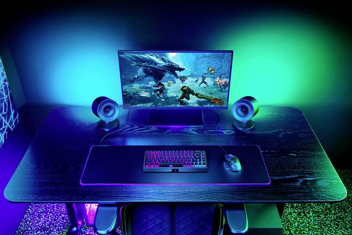Ein ergonomischer Gaming-Schreibtisch mit beleuchtetem Monitor, Tastatur und Maus, alle in blauem, grünem und violettem Lichtschein.