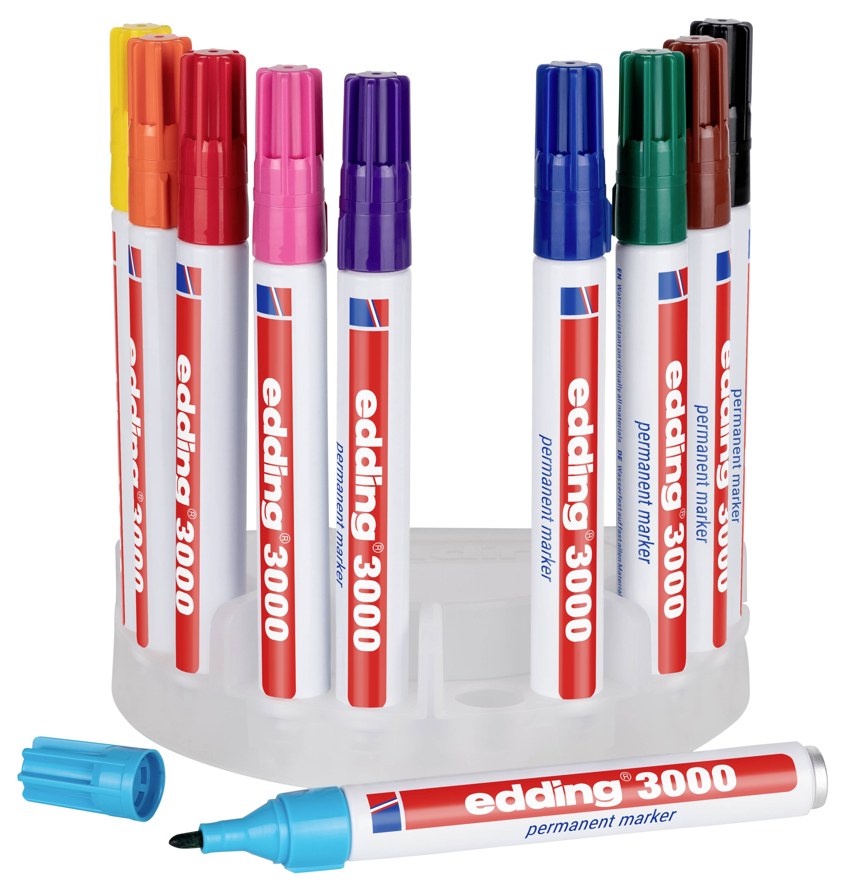 Assortierte Edding 3000 Permanentmarker in einem runden Kunststoffhalter, mit einem blauen Marker, der vorne liegt und dessen Kappe ab ist.