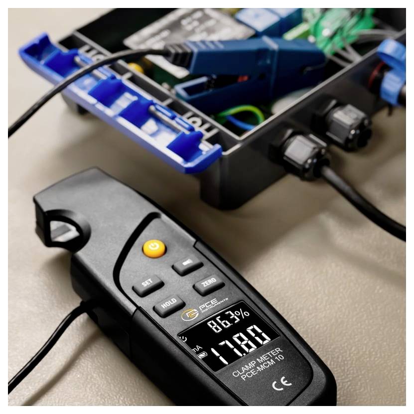Digitales Zangenampermeter zeigt 78,0A und 86,7% auf der Vorderseite einer offenen Elektroverteilung mit Drähten und Steckverbindern.
