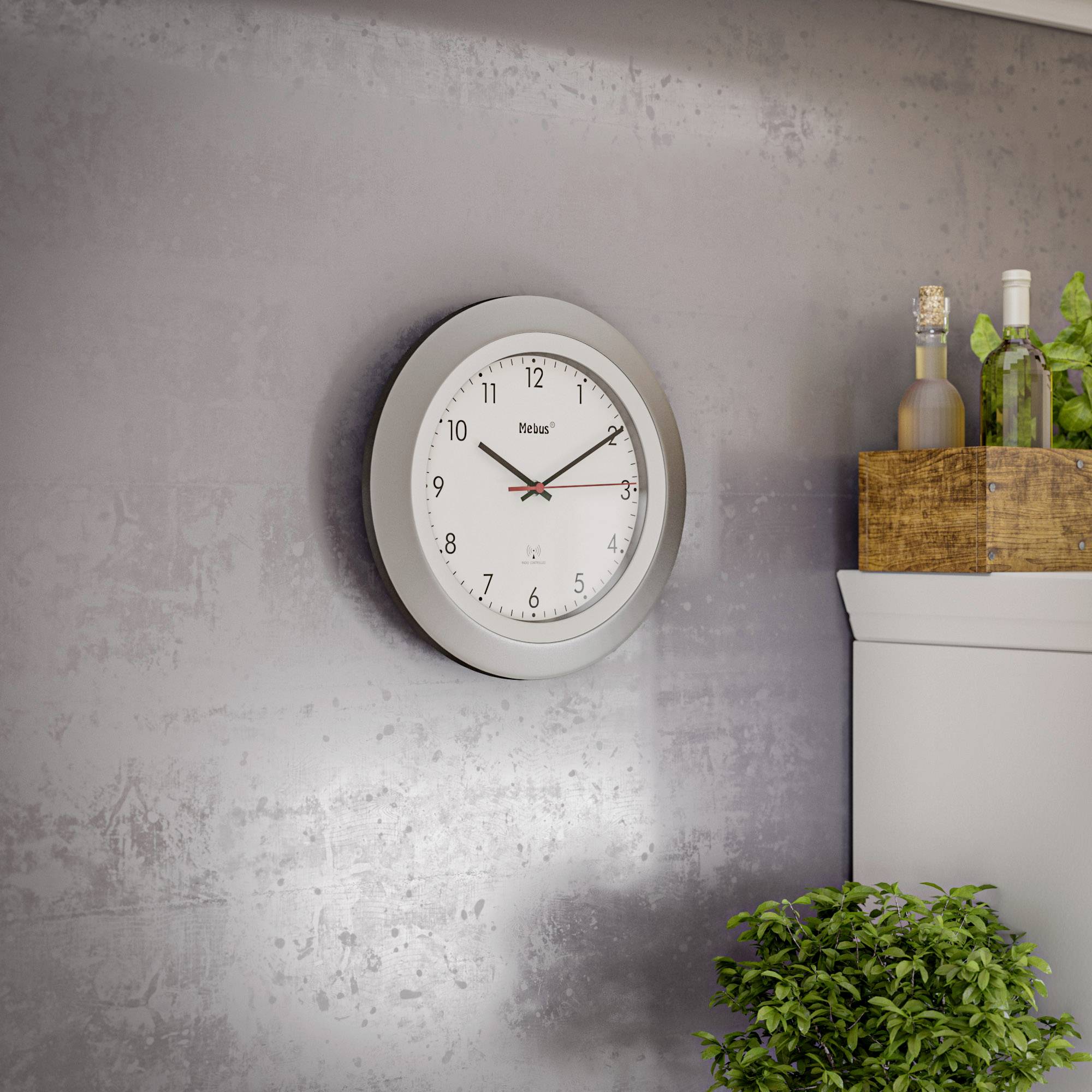 An einer grauen Wand hängt eine runde Uhr mit weißem Ziffernblatt und schwarzen Zeigern. Daneben stehen Flaschen auf einem Holzregal.