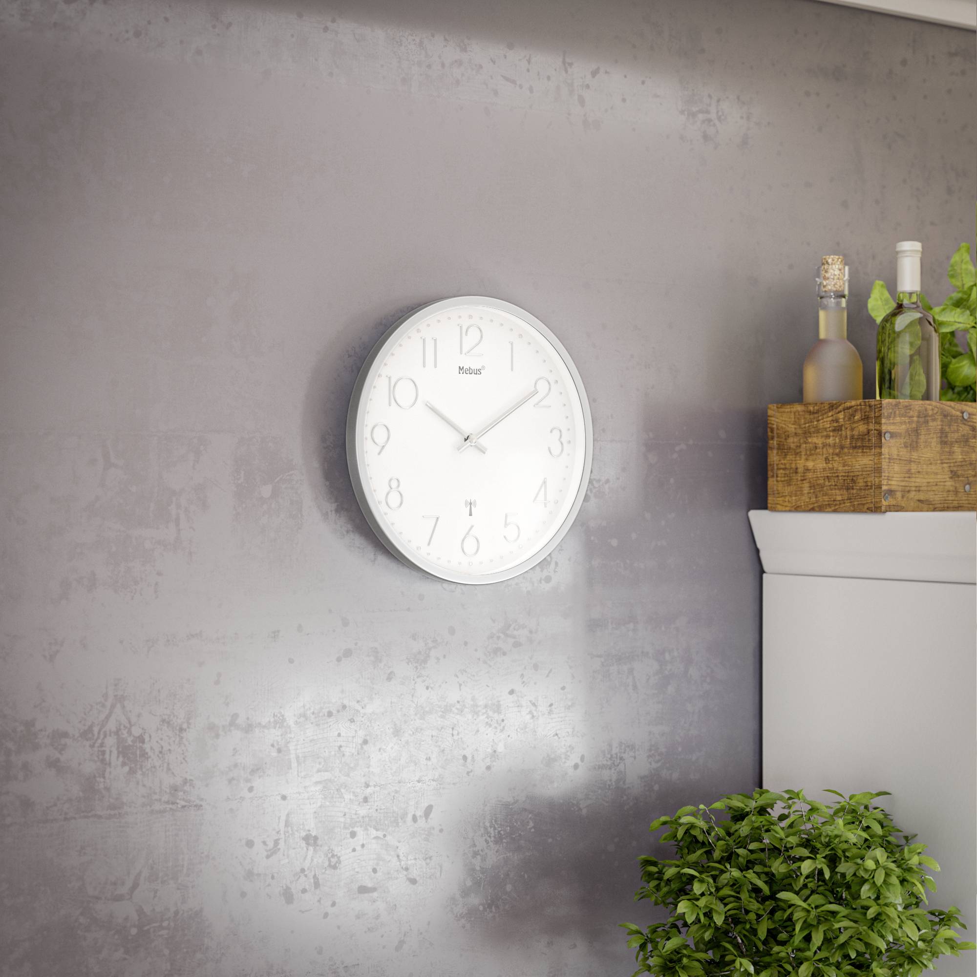 Eine Wanduhr zeigt etwa 10:11 Uhr. Daneben steht ein Holzkasten mit Flaschen und Pflanzen auf einem Schrank.