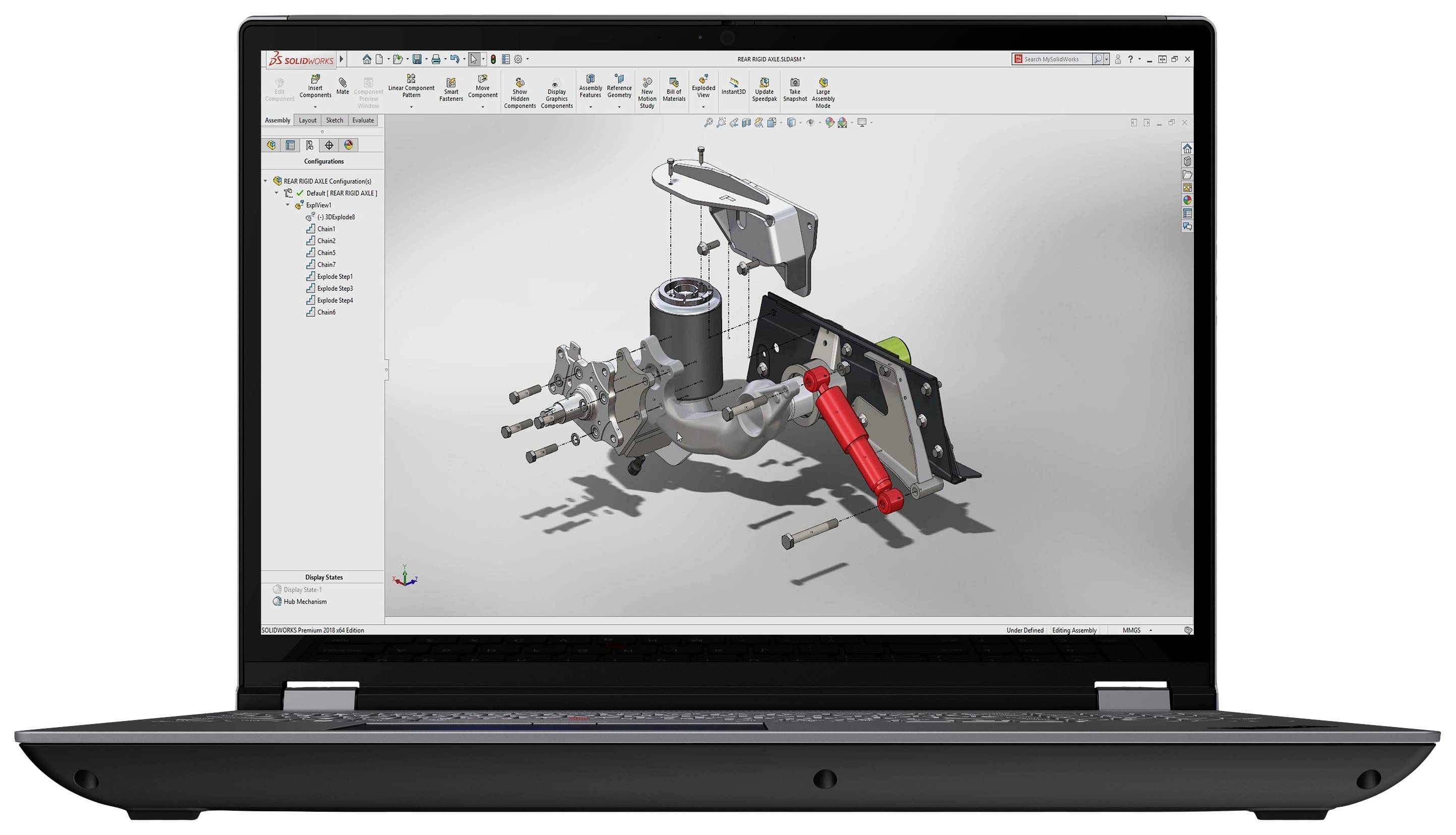 Laptop mit CAD-Software, zeigt ein 3D-Modell einer technischen Baugruppe mit Schrauben und Zylinder, umgeben von Bearbeitungswerkzeugen.