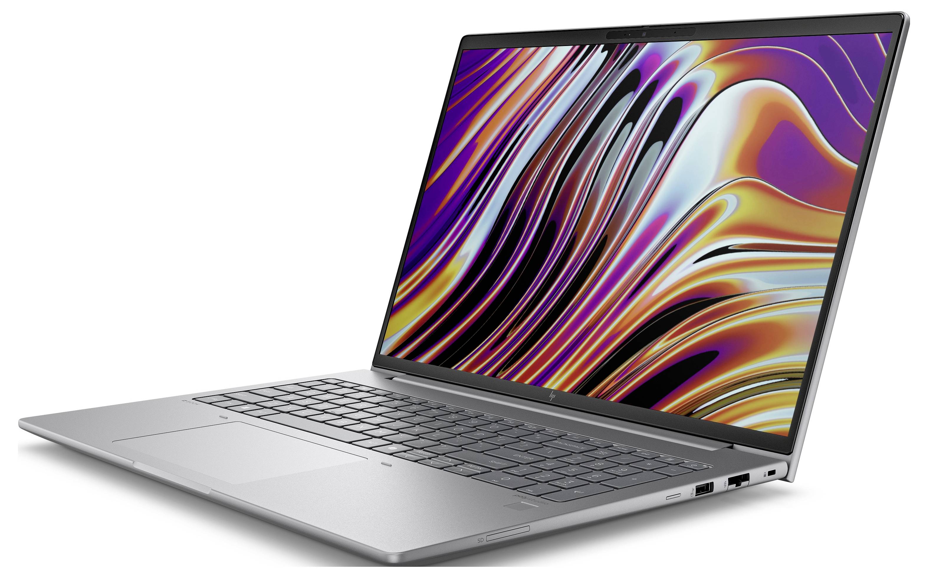 Ein silberner Laptop mit einem bunten, wellenförmigen Muster auf dem Bildschirm, das dynamische Farben zeigt.