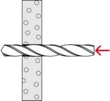 Bohrer tritt von links in perforiertes Metallblech ein, gekennzeichnet durch einen roten Pfeil, der die Bohrrichtung anzeigt.