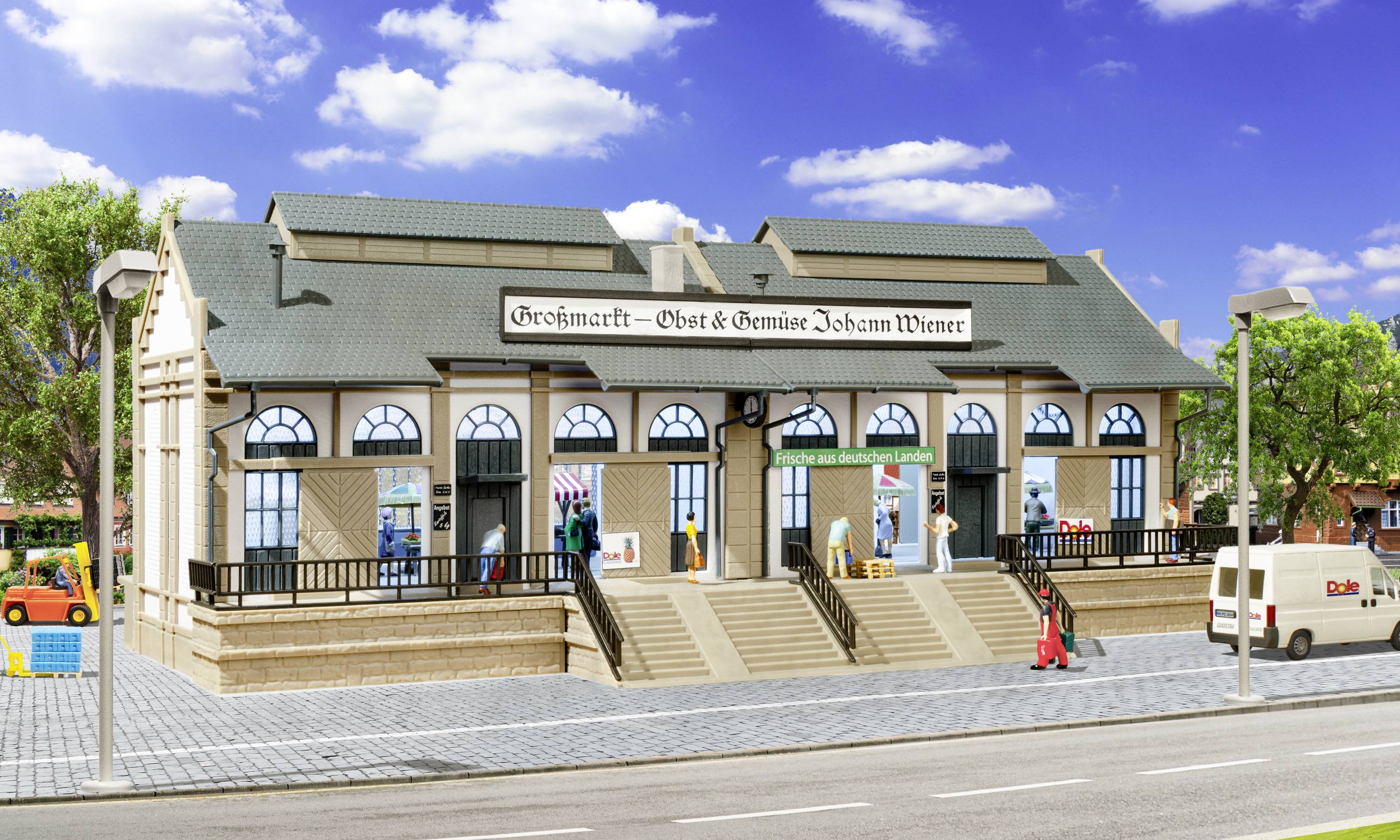 Zweistöckiges Gebäude mit Aufschrift 'Großmarkt – Obst & Gemüse Johan Wiener'. Menschen betreten es über Stufen, Lieferwagen parkt daneben.