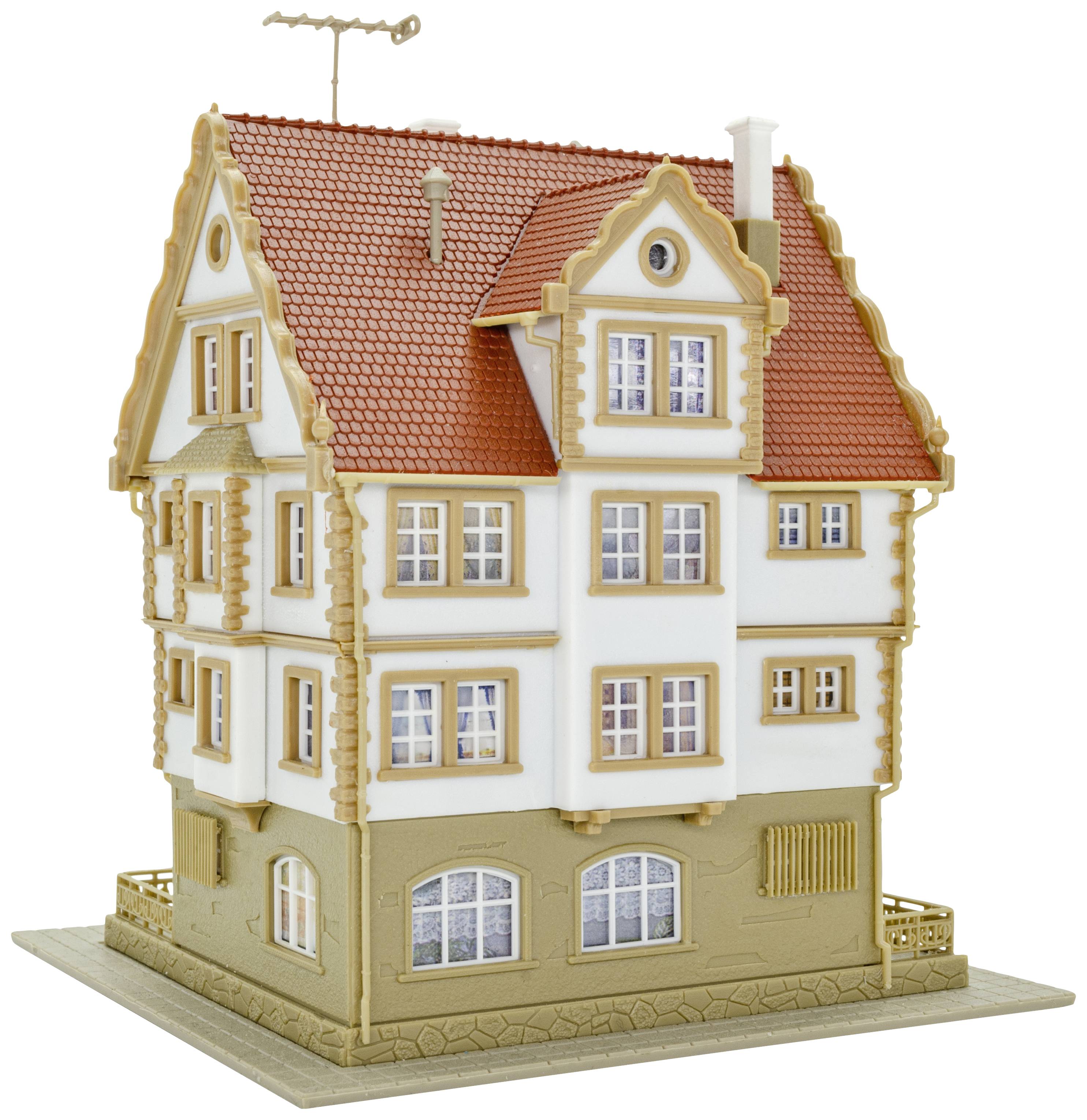 Ein Modellhaus zeigt ein dreistöckiges Gebäude mit roten Dachziegeln, weißer Fassade und verzierten Fenstern.