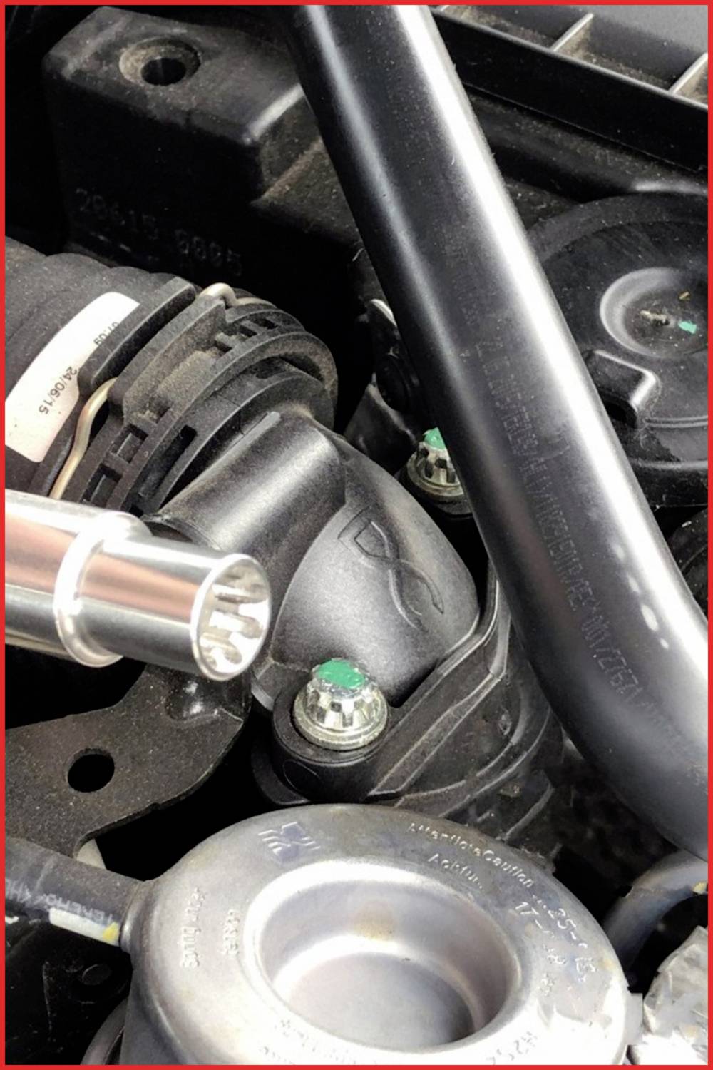 Autoteilmotoransicht mit schwarzen und silbernen Komponenten. Ein grüner Schraubenkopf sichtbar. Technisches Detail.