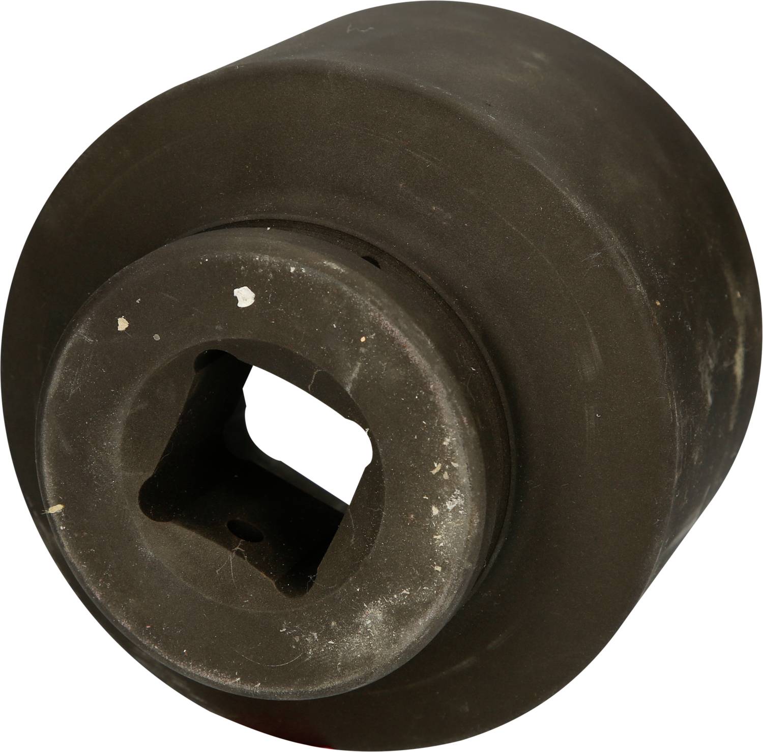 Ein rundes Metallwerkzeug mit quadratischem Loch in der Mitte, vermutlich eine Art Aufsatz oder Adapter. Oberfläche ist leicht abgenutzt.