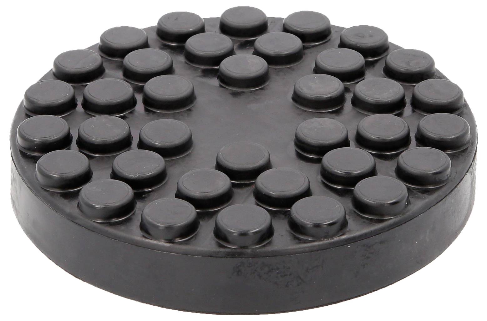 Eine kreisförmige, schwarze Gummiauflage mit erhobenen kreisförmigen Noppen, verwendet als Antirutschunterlage für Wagenheber.
