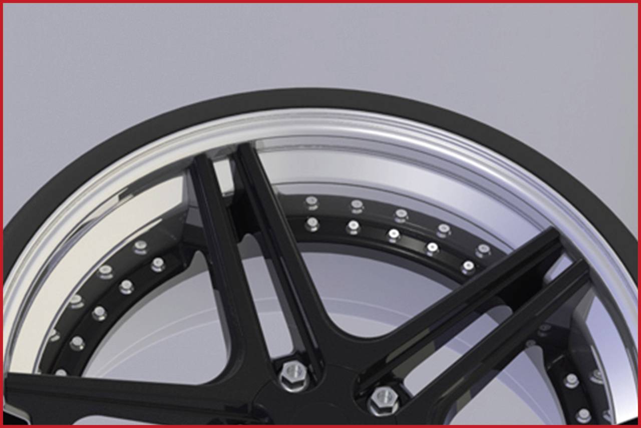 Nahaufnahme eines schwarzen Autoreifen-Felgendesigns mit polierten Details und Schrauben entlang des Randes.