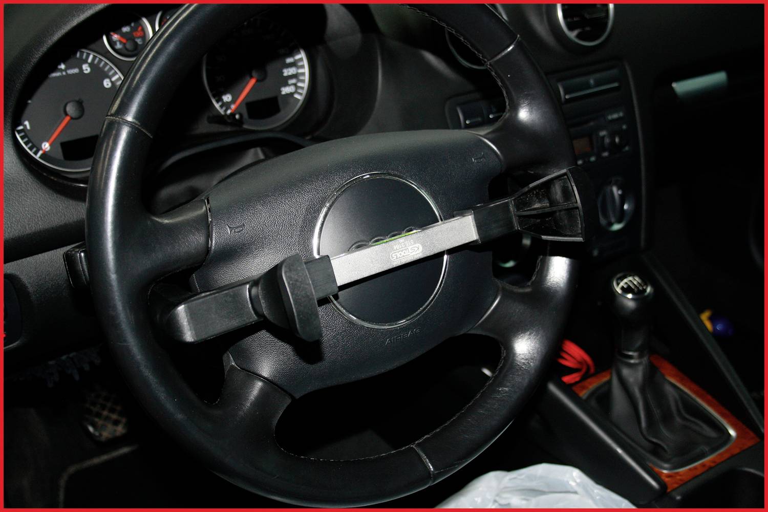 Lenkradkralle im Auto angebracht. Lenkrad zeigt Armaturenbrett mit Tacho und Schaltknüppel im Hintergrund.