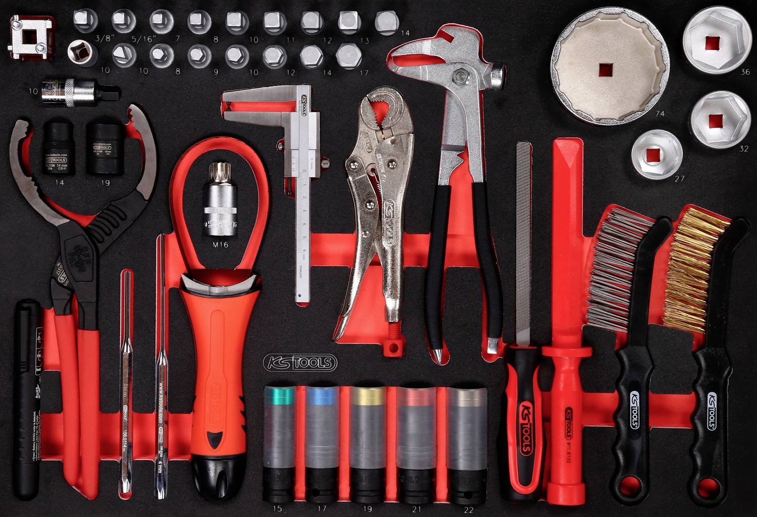 Ein Satz roter und schwarzer Handwerkzeuge, darunter Schraubenschlüssel, Zangen, Schraubendreher und Bürsten, auf einer Ablage.