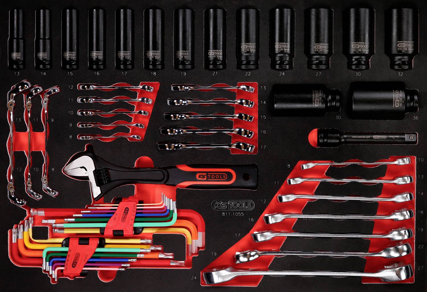 Ein Werkzeugkasten mit verschiedenen Steckschlüsseln, Schraubenschlüsseln und einem verstellbaren Schraubenschlüssel auf schwarzem Hintergrund.