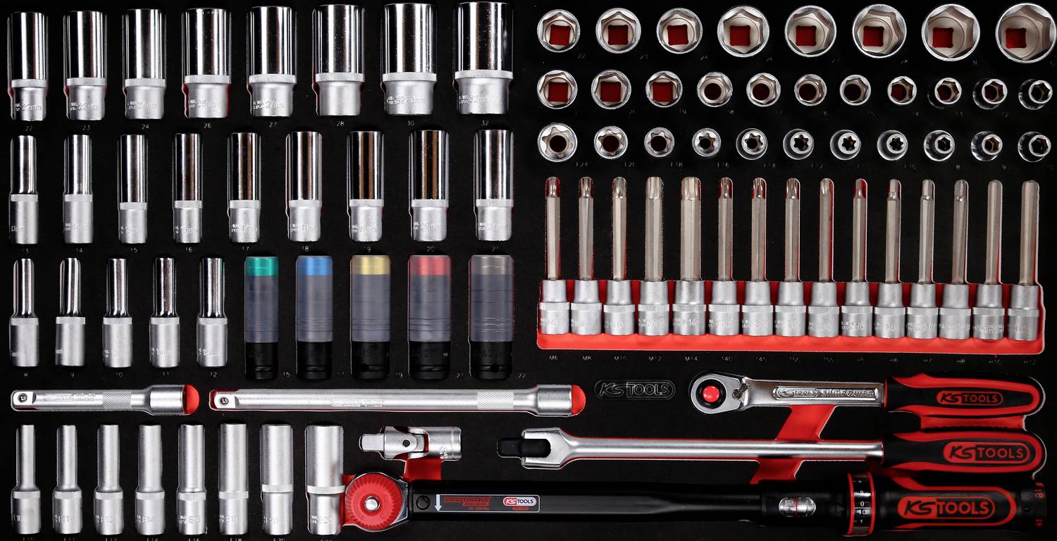 Ein Set von Handwerkzeugen, darunter Steckschlüssel in verschiedenen Größen, farbcodierte Schlüssel und Schraubwerkzeuge, auf schwarzem Hintergrund angeordnet.