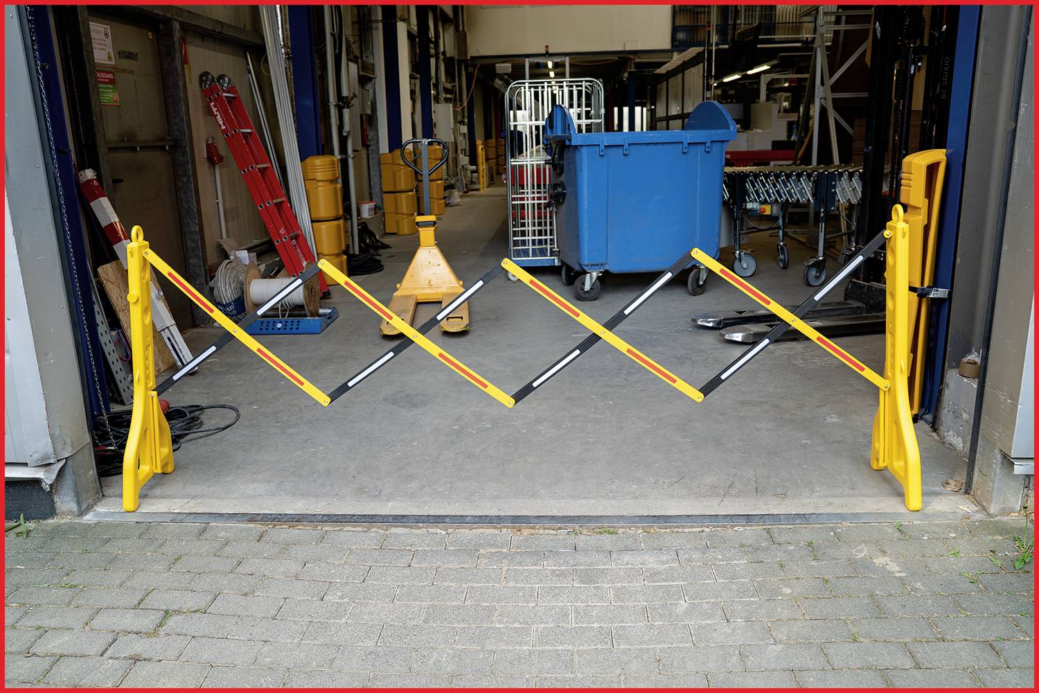 Gelbes Absperrgitter blockiert Zugang zu Lagerhalle. Im Hintergrund stehen ein blauer Container und Lagerregale. Sicherheitsmaßnahme.