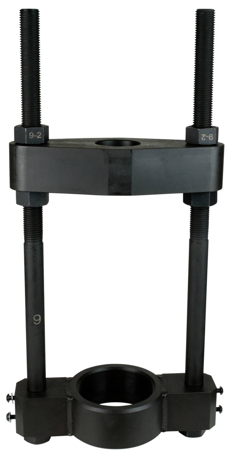 Ein schwarzes Metallwerkzeug zur mechanischen Anwendung, bestehend aus zwei langen Schrauben und einem zentralen Ring, vermutlich ein Abzieher.