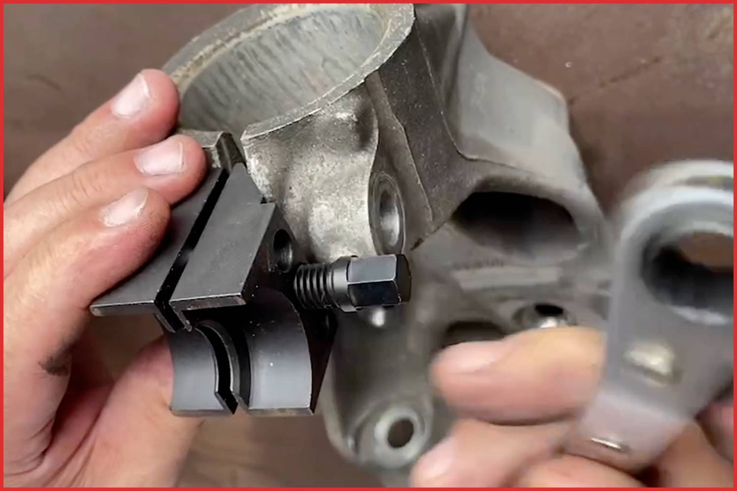 Hand mit Werkzeug befestigt Bauteil an Metallrahmen.