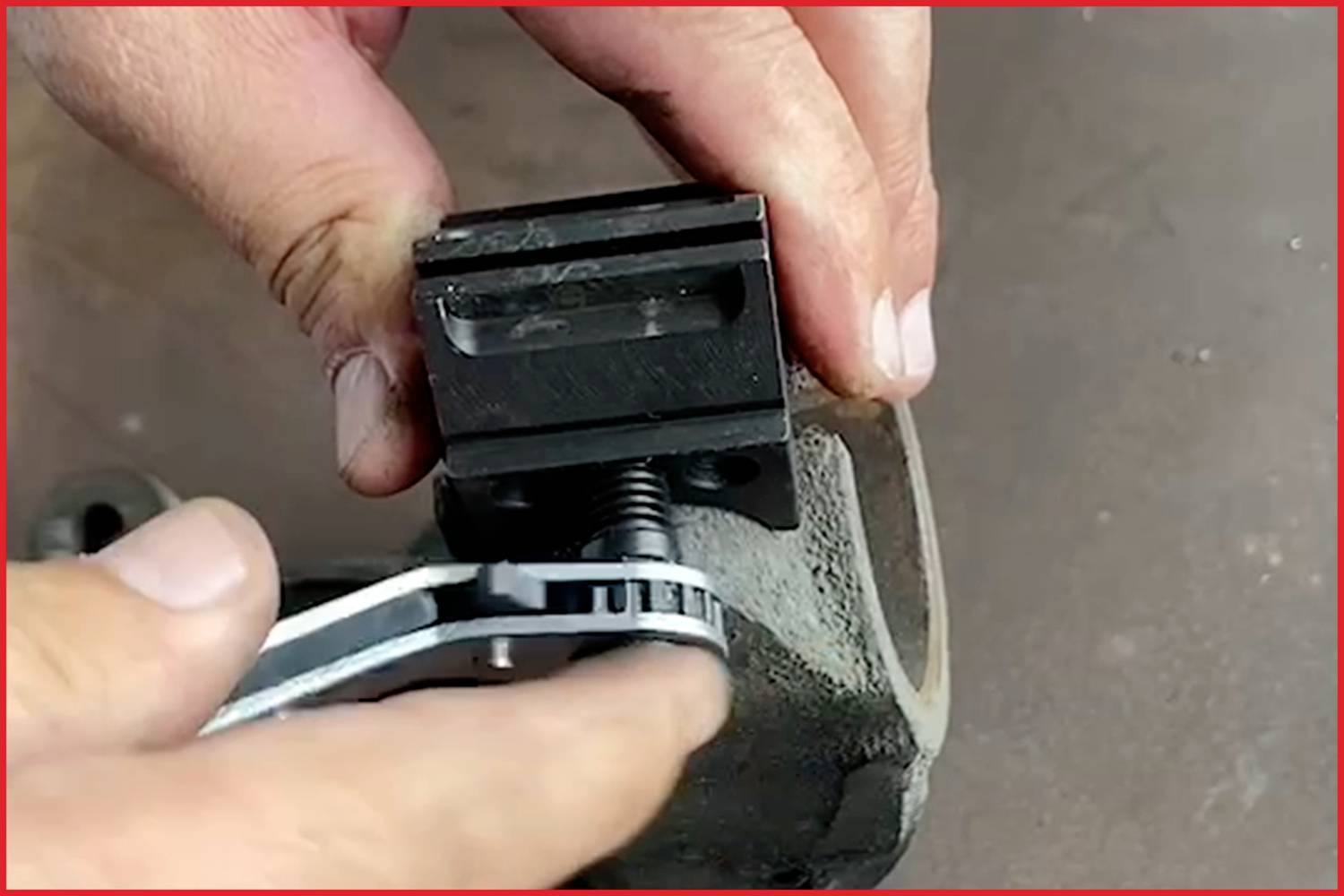 Eine Person zieht mit einem Schraubenschlüssel eine Schraube an einer metallischen Befestigung an.