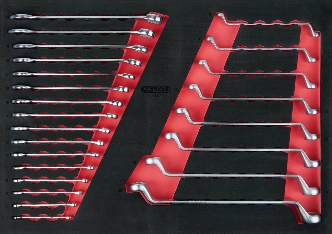 Schraubenschlüsselsatz in roten Halterungen, auf schwarzem Hintergrund. Die Schlüssel sind unterschiedlich groß und aus Metall.