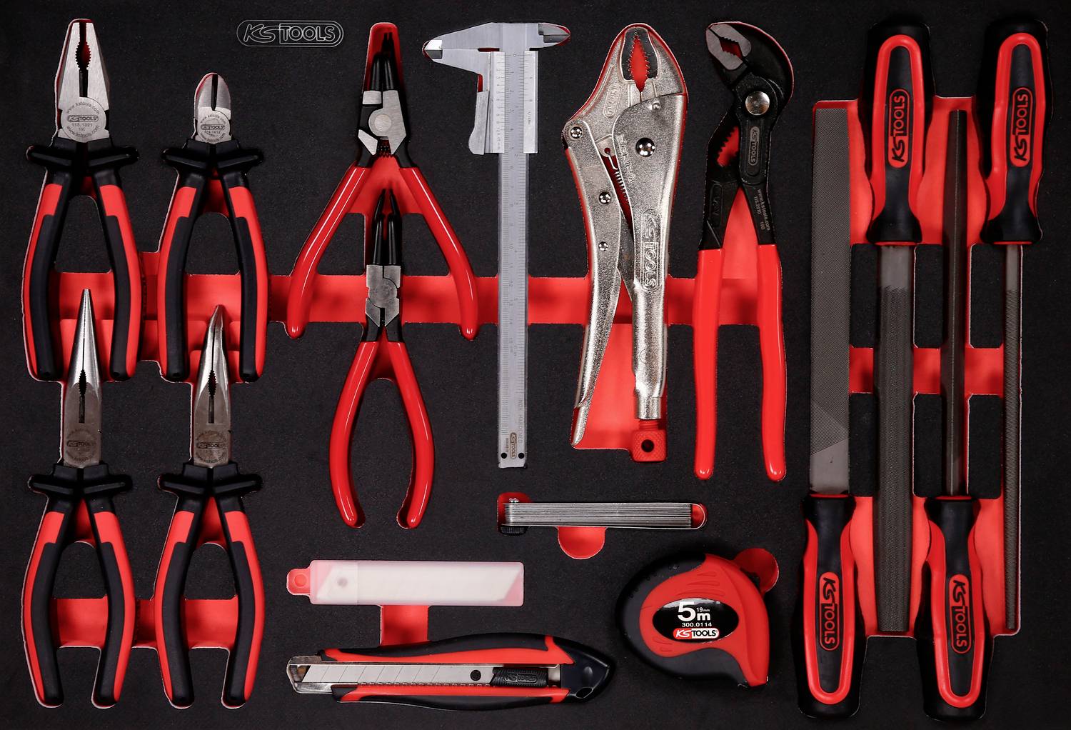 Werkzeugset mit Zangen, Schraubenschlüsseln, Maßband, Feilen und Cutter, ordentlich auf schwarzem Hintergrund angeordnet.