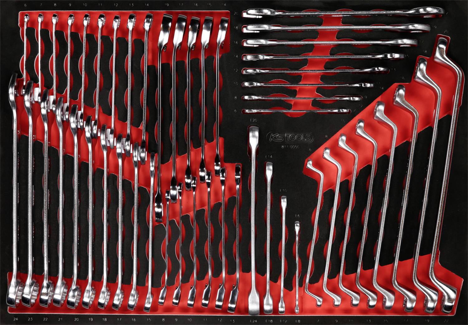 Satz Schraubenschlüssel in verschiedenen Größen, ordentlich in einem schwarzen und roten Werkzeugkasten angeordnet.