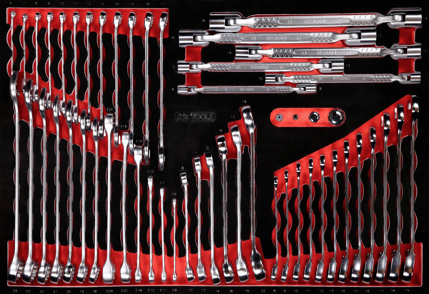 Ein Set von Metall-Ringschlüsseln in verschiedenen Größen, ordentlich in einem roten Halter angeordnet.