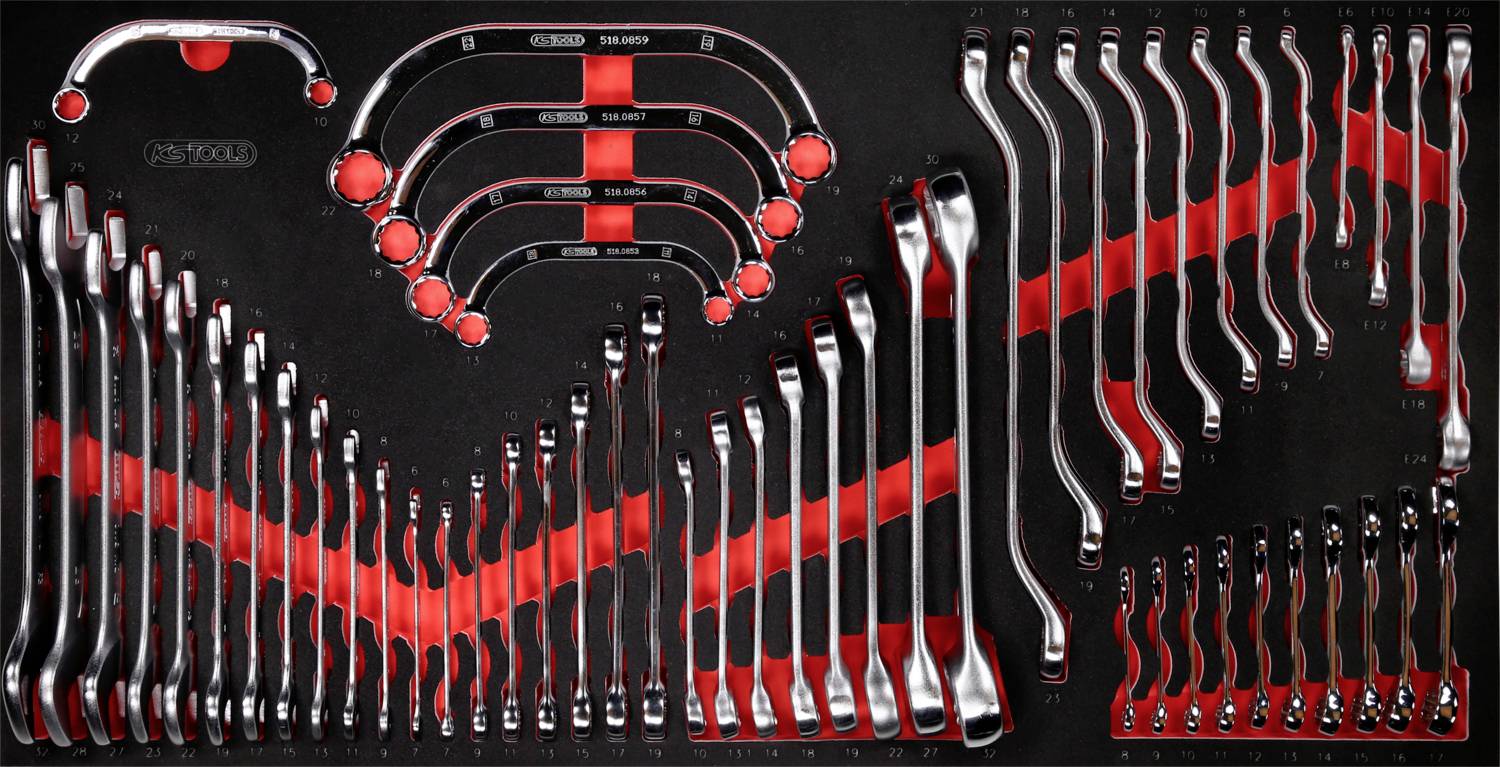 Eine geordnete Sammlung von Ringschlüsseln in verschiedenen Größen, farblich markiert, auf schwarzem Hintergrund angeordnet.