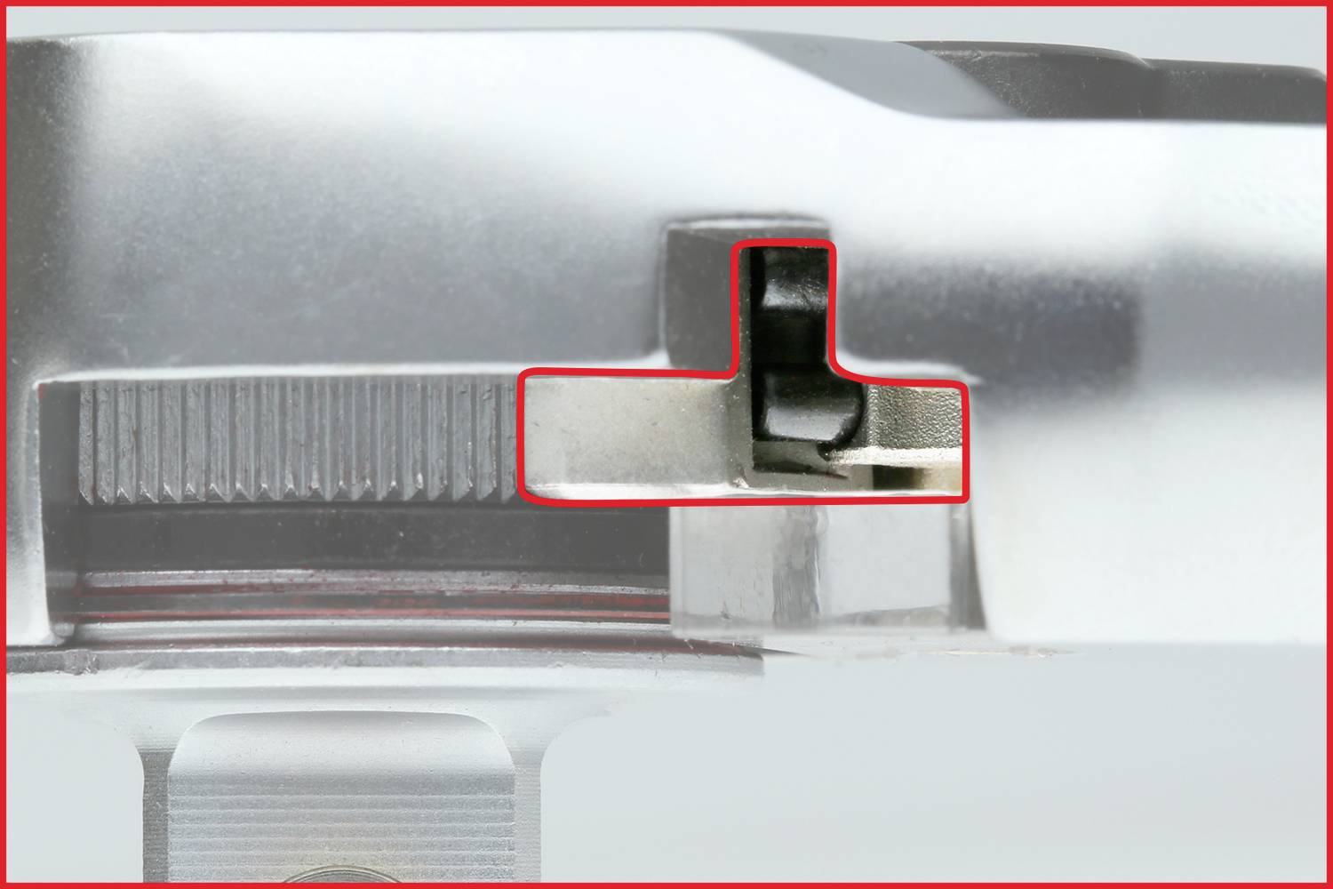 Nahaufnahme eines metallischen Mechanismus mit hervorgehobenem rechteckigem Detail. Details des inneren Mechanismus sind sichtbar.