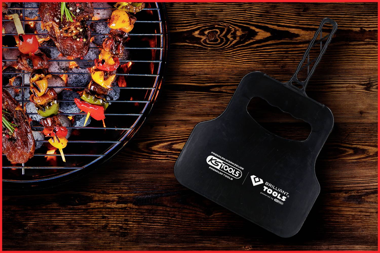 Grill mit buntem Gemüse und Fleischspießen links, rechts ein schwarzer Grillhandschuh mit Markenlogos auf dunklem Holztisch.