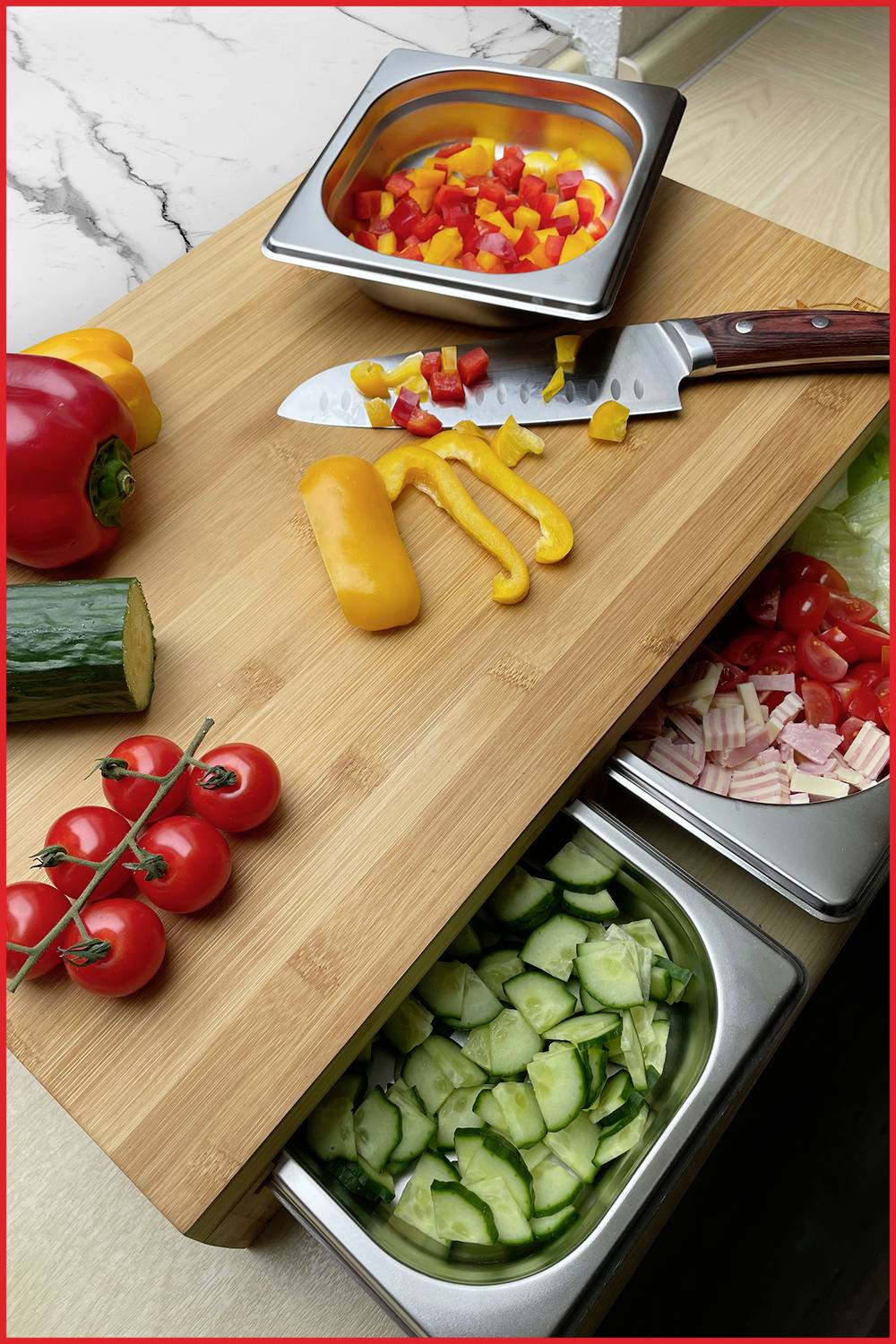 Schneidebrett mit geschnittenem Gemüse: Paprika, Tomaten, Gurken. Messer liegt daneben. Verwendung in der Essenszubereitung.