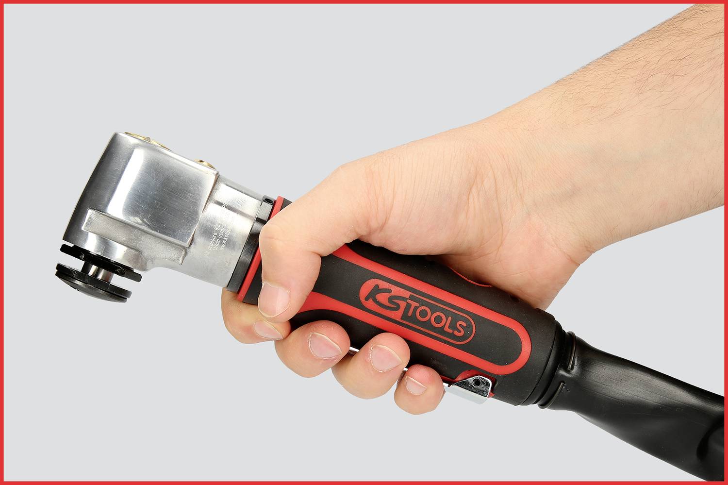 Eine Hand hält ein Werkzeug mit der Aufschrift 'KS Tools', erkennbar an einem gepolsterten Griff und einem metallischen Kopf.