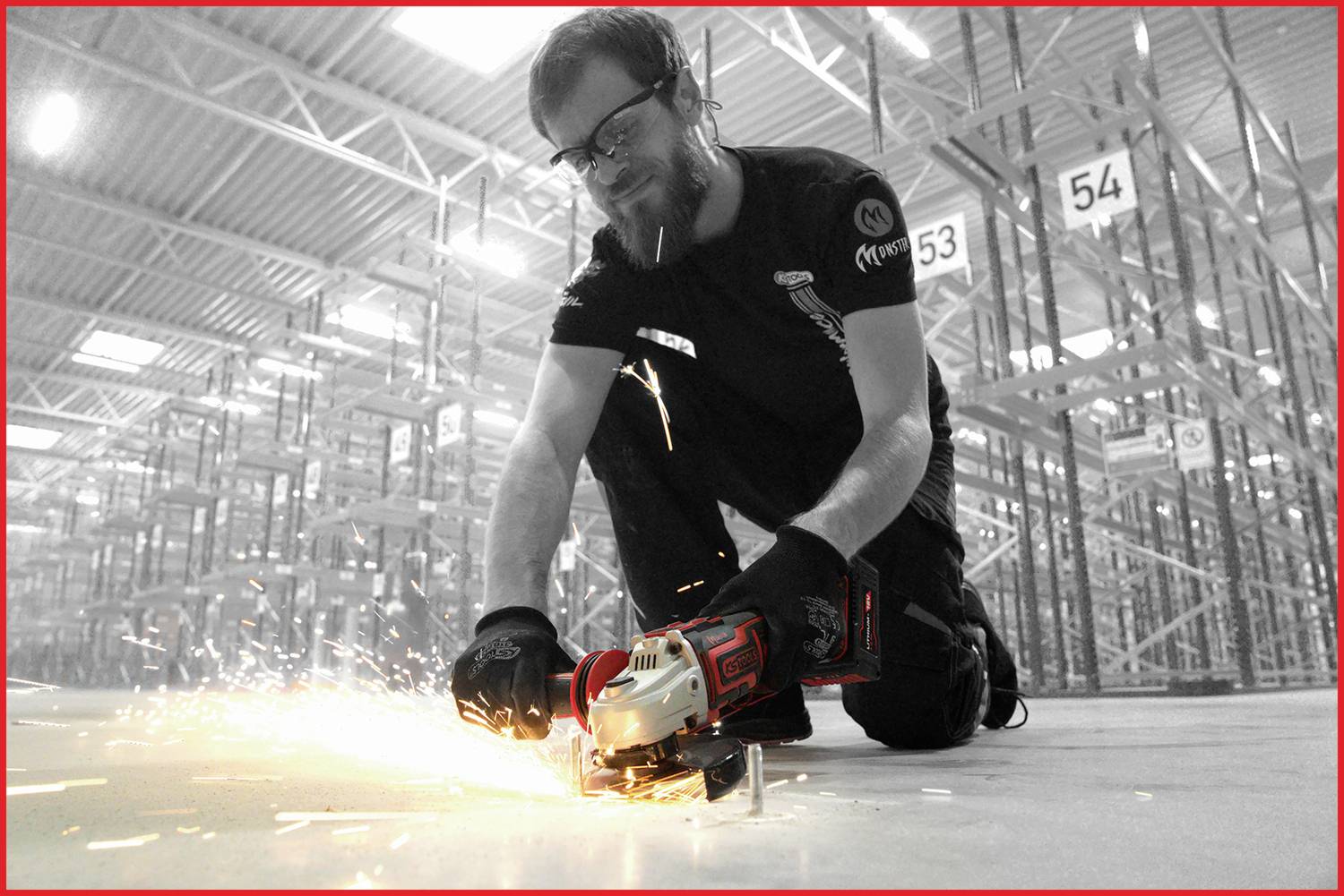 Ein Mann arbeitet in einer Lagerhalle und schneidet mit einem Winkelschleifer Metall. Funken sprühen, Regale im Hintergrund.