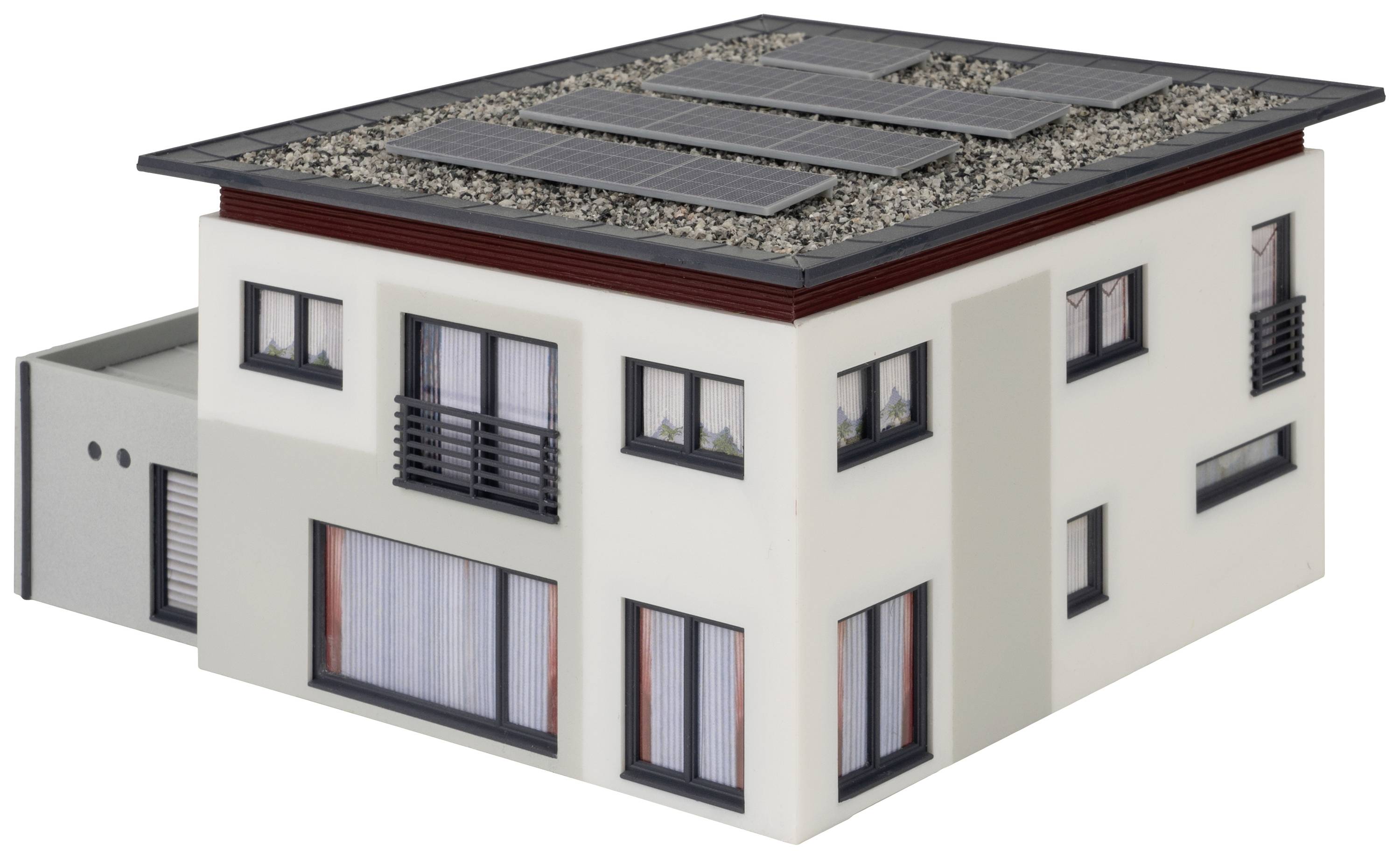 Zweistöckiges modernes Gebäude mit Flachdach, Solarzellen darauf. Große Fenster, weißer Anstrich, Garage auf der linken Seite.