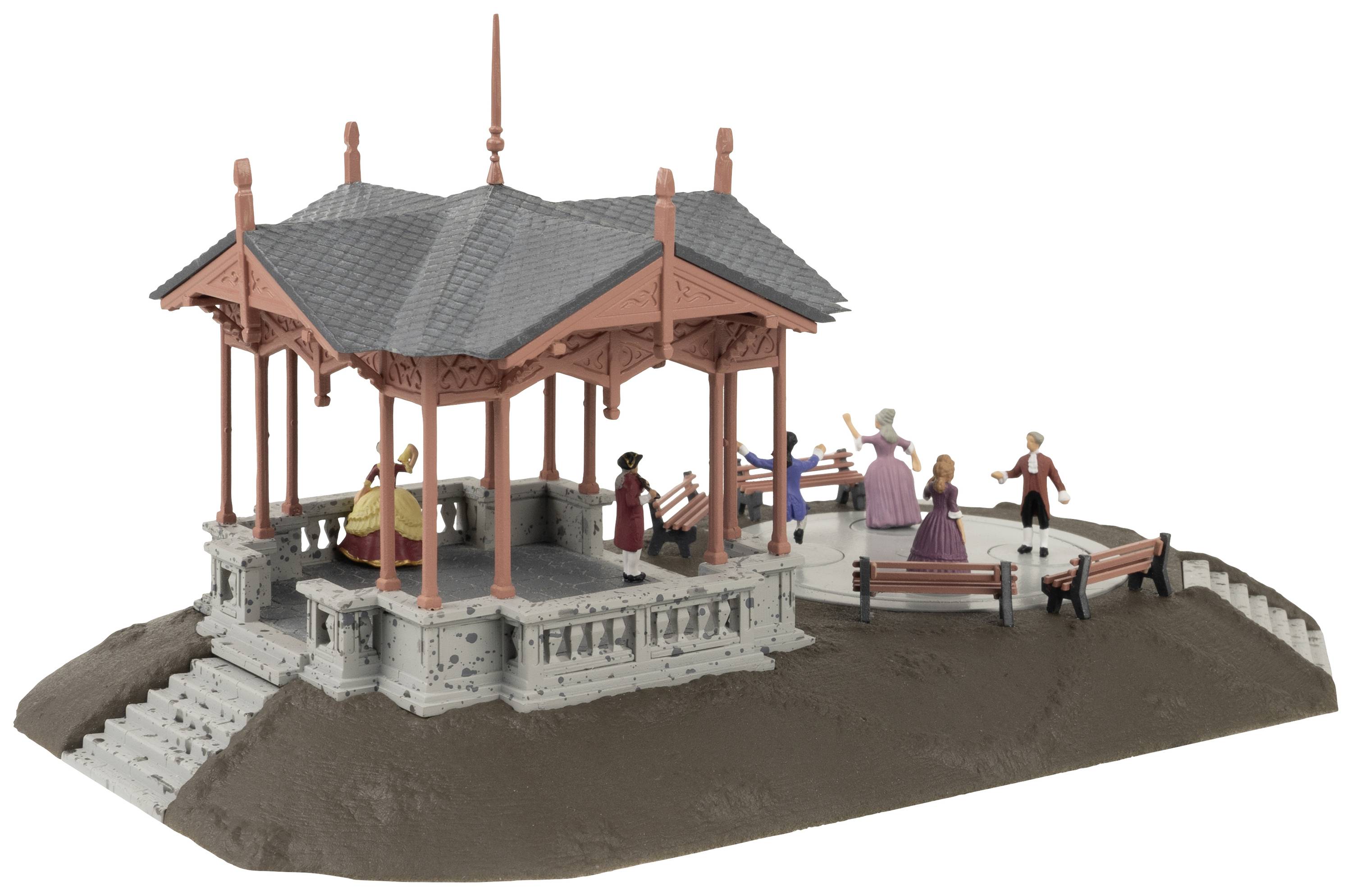 Ein Miniaturpavillon mit Figuren auf Bänken und spielenden Kindern. Eine Dame mit Hut unterhält sich stehend mit einem weiteren Herr.