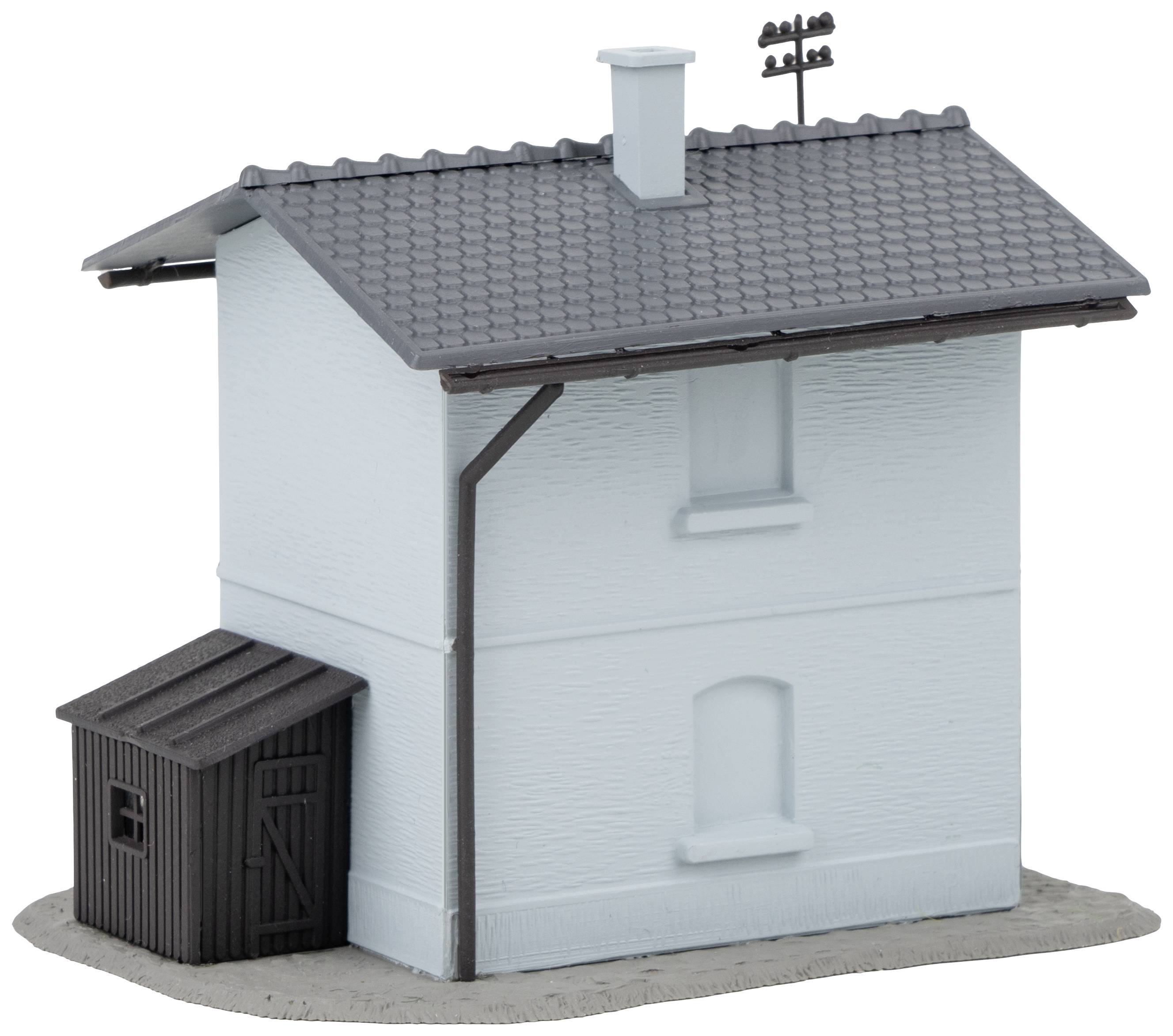 Ein kleines, hellblaues Modellhaus mit einem dunkelgrauen Dach und einem Schuppen an der Seite; es steht auf einer grauen Basis.